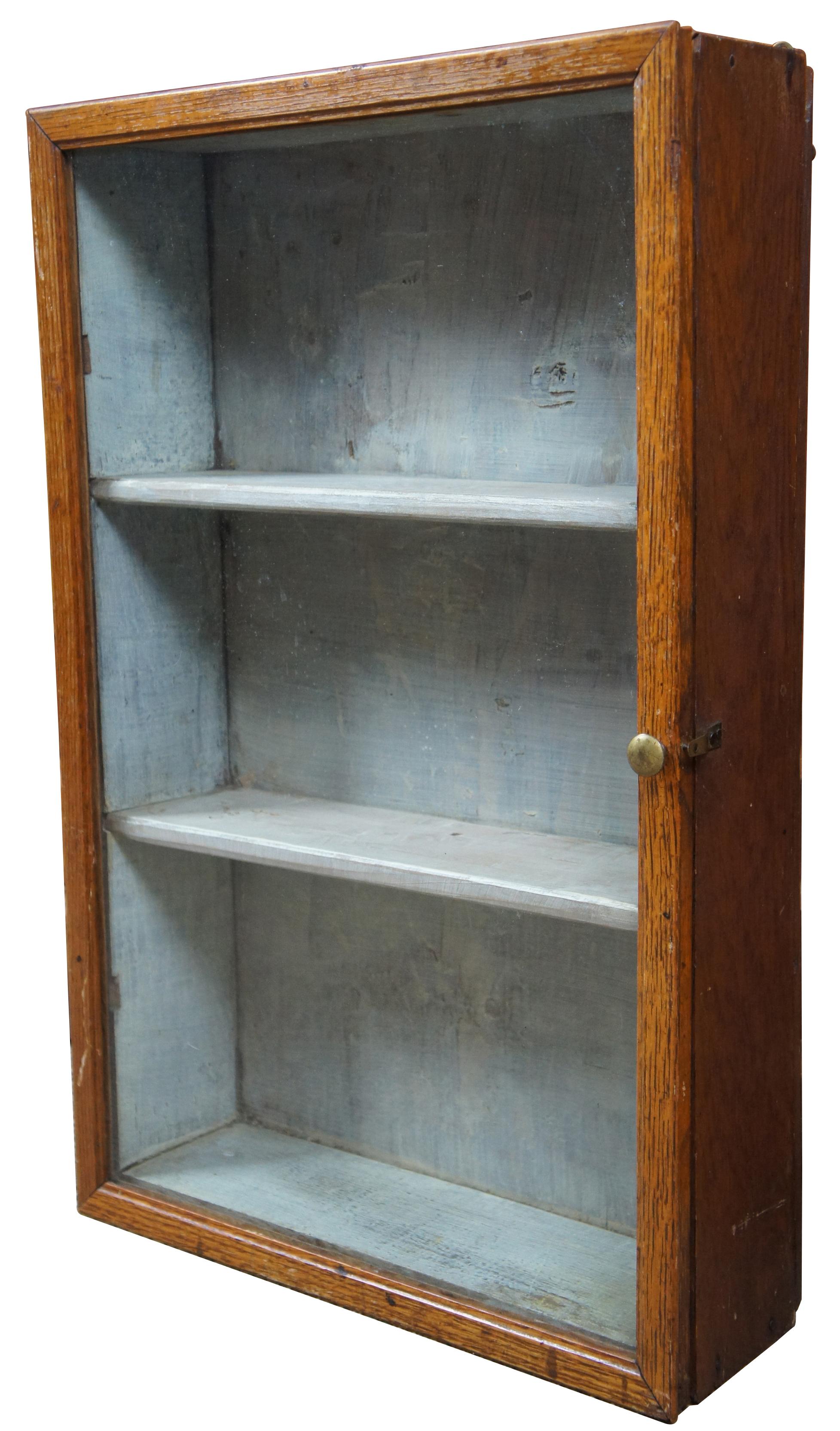 Antique wall hanging cabinet with glass front, three shelves and pale blue painted interior. Great for a bathroom nook or display of any collectibles.
 