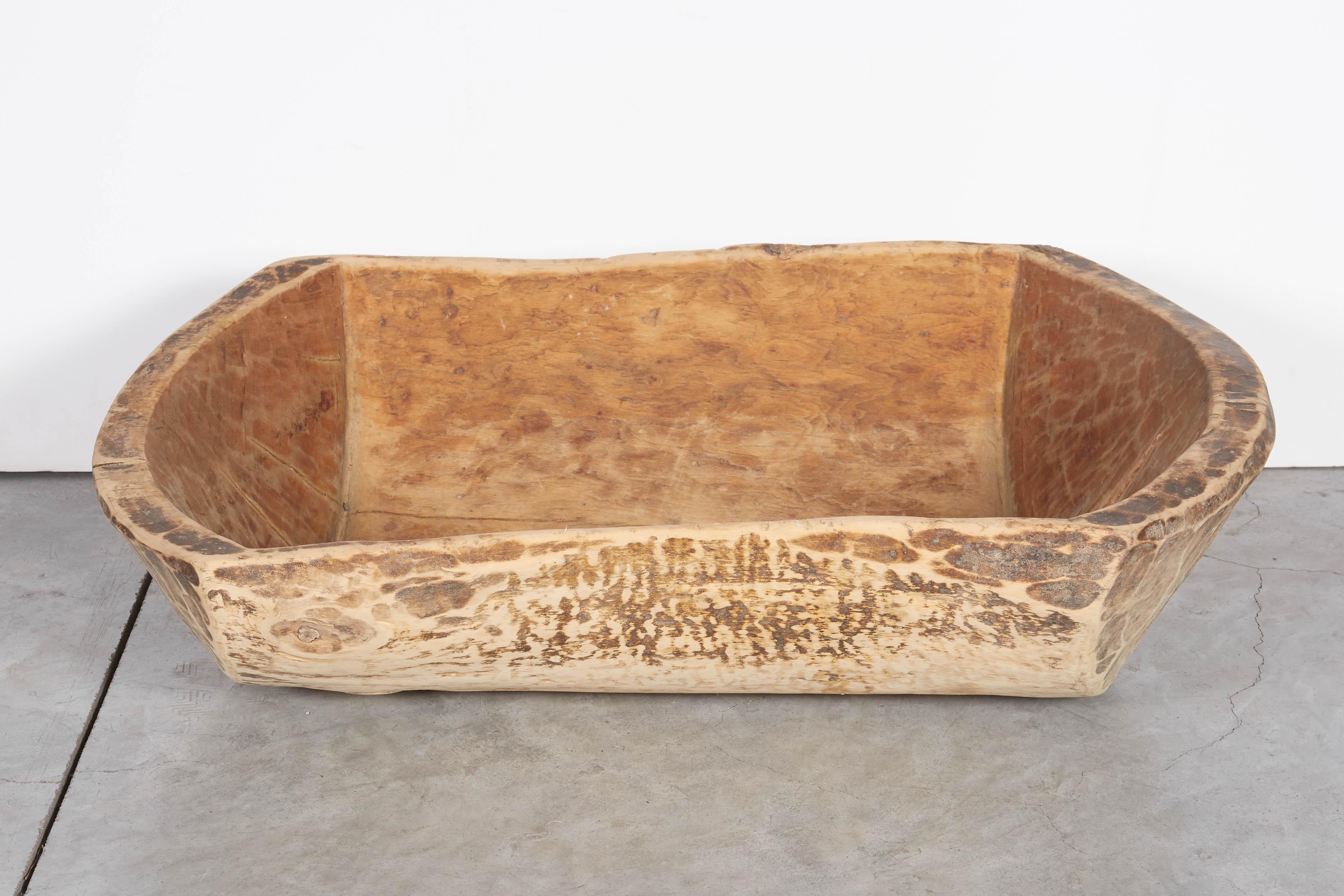 An antique Chinese bowl carved from a single piece of pine wood. This piece has a striking, irregular shape and shows the beautiful wear which is the result of more than one hundred years of use. 
TR124.