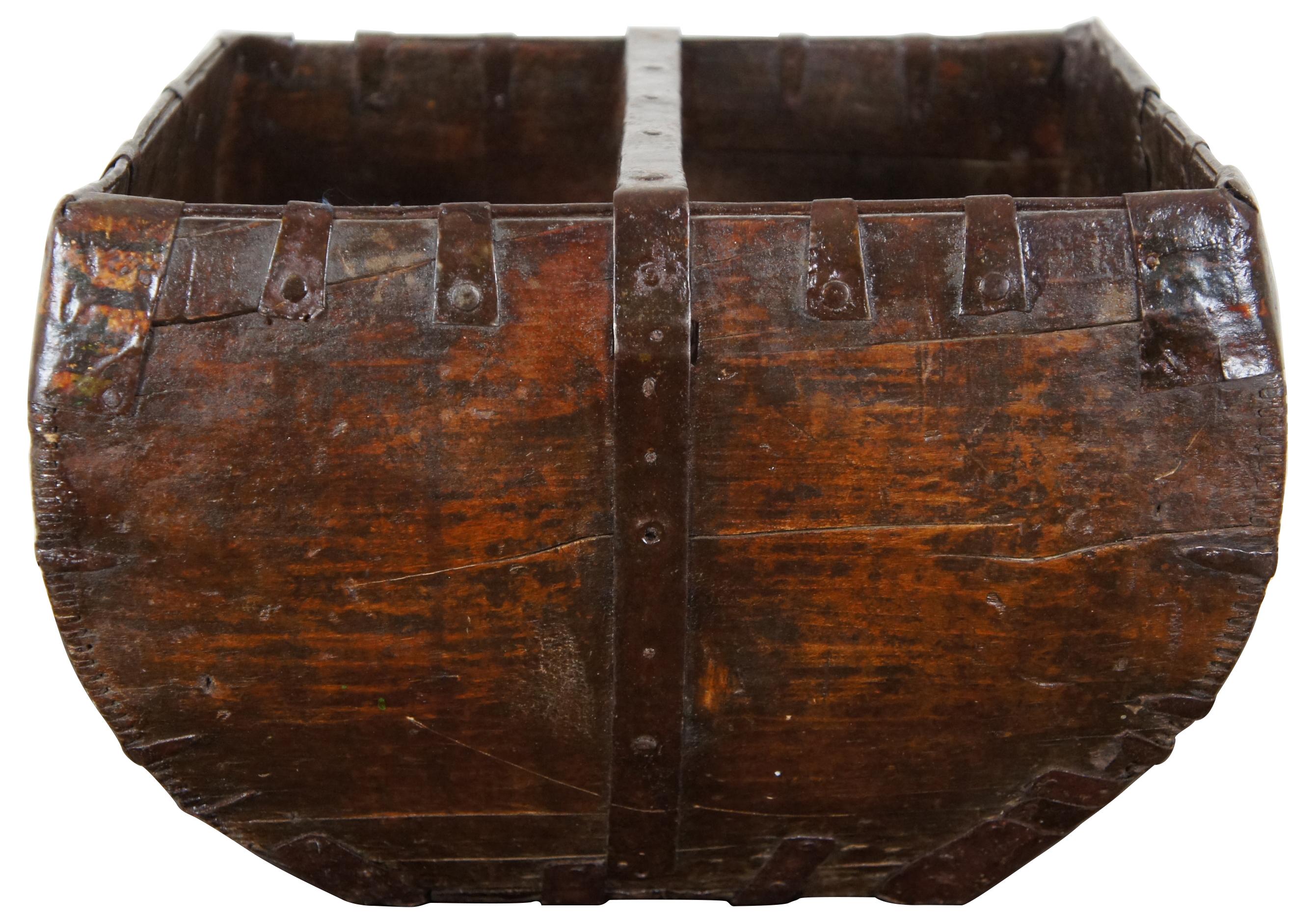 Antique wooden grain or rice measure / harvesting bucket with handle across the middle and primitive iron accents.
  