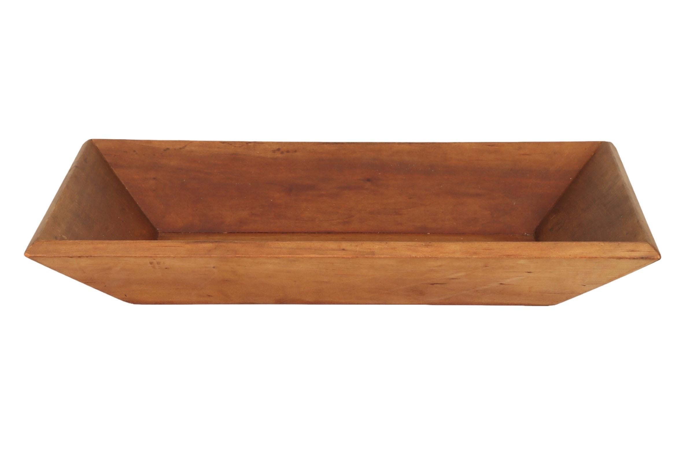 Eine rechteckige antike Teigschüssel im primitiven Stil oder eine Grabenschüssel. Seit der Kolonialzeit waren diese Holzschüsseln in jedem Haushalt zu finden, um Brotteig zu mischen.
