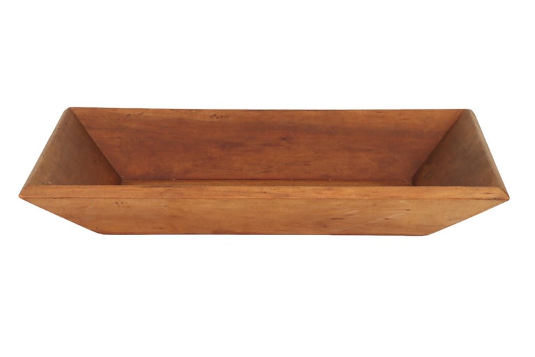 A primitive style rectangular antique dough bowl or trencher bowl. Since colonial times these wooden bowls were found in every home to mix bread dough.
 