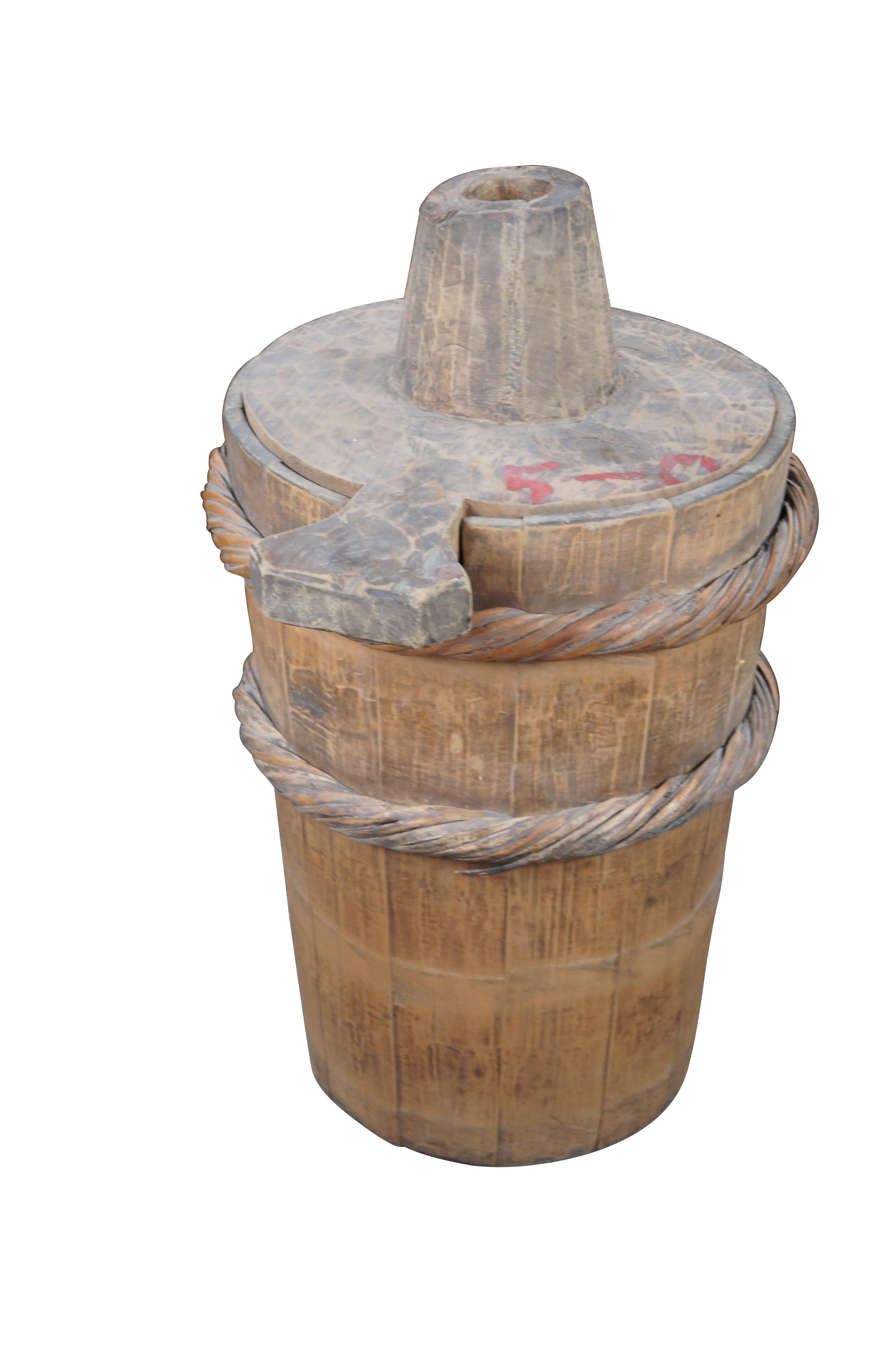 A large primitive pine butter churn. Features a removable lid and braided wicker accents. A neat addition to any farmhouse setting.

Dimensions:
31