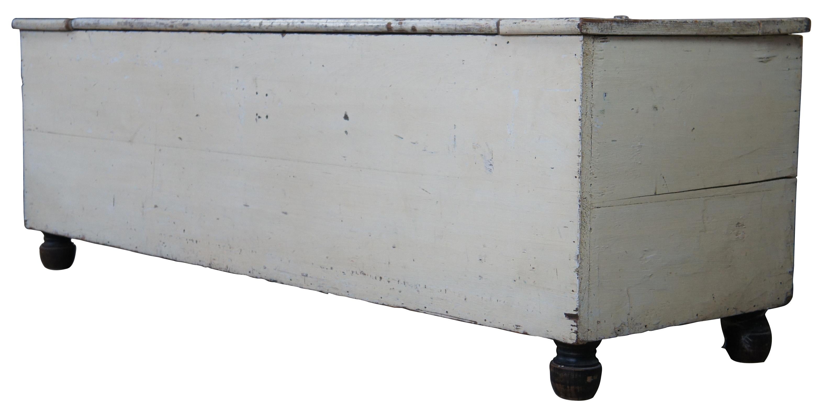 Antique footed pine trunk or bench. Made of pine featuring a distressed white painted patina over bun feet.
 