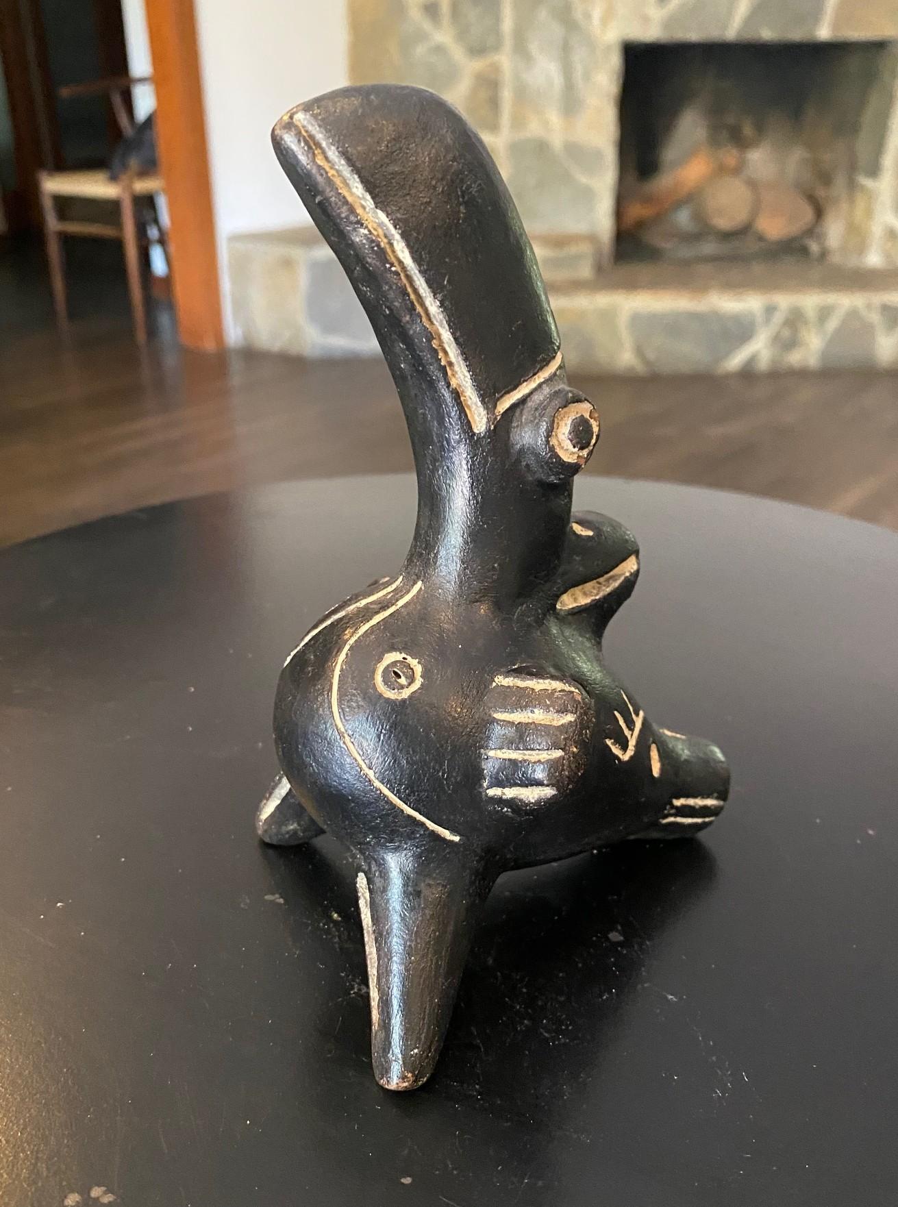 An interesting and rather unusual primitive Pre-Columbian style Native South or Central American (Mesoamerican) primitive bird sculpture/ instrument.  We believe this piece is a hand painted clay ocarina - a flute like instrument that was used by