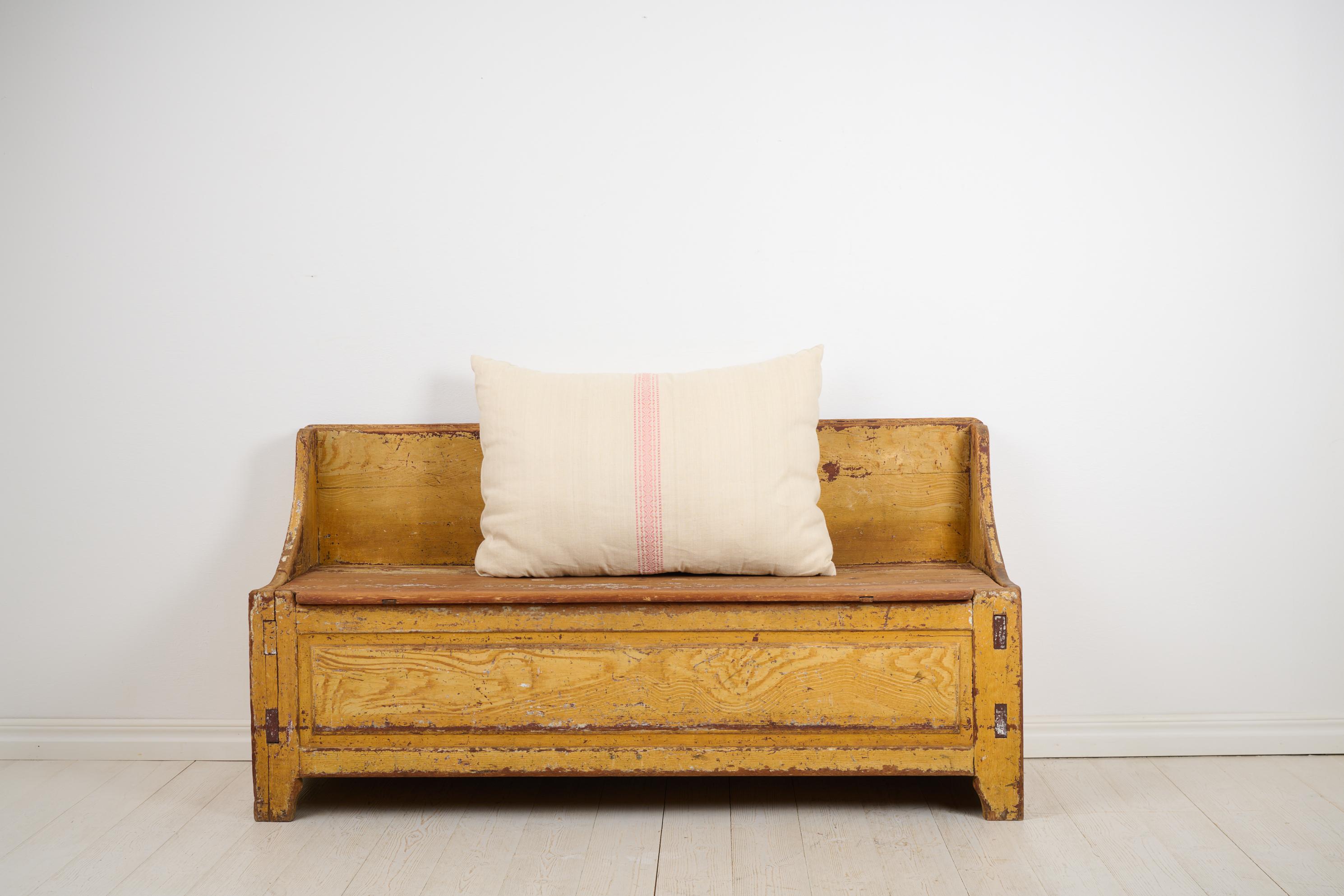 Banc suédois antique rustique en art populaire du nord de la Suède. Le banc est fabriqué vers 1820 à la main avec un cadre en pin massif. Siège original avec un grand espace de rangement en dessous. Ancienne peinture historique, fausse peinture
