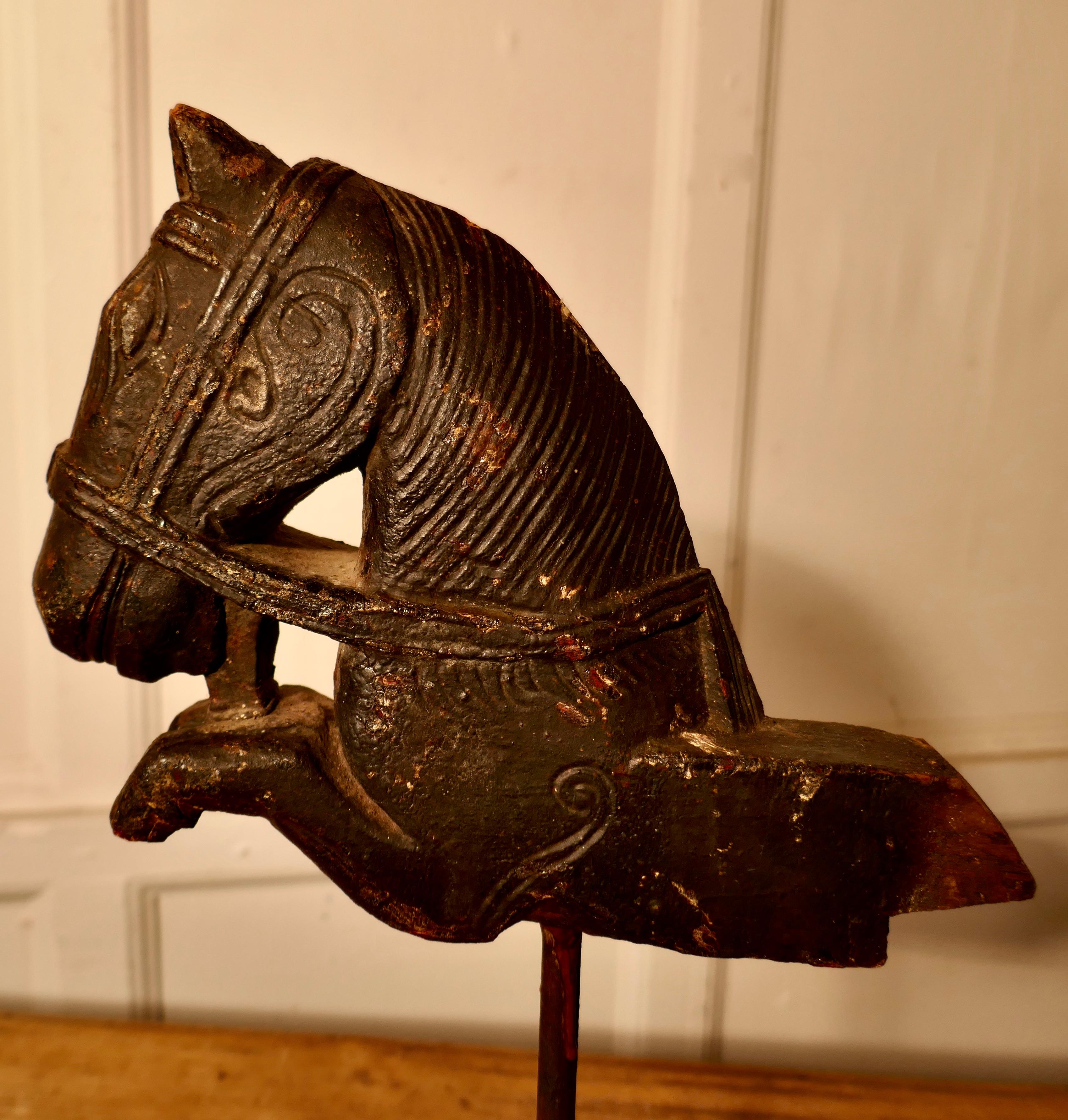 Primitive architectural carved wood mounted Indian horse head 

A beautiful piece of folk architecture from the Indian continent, the horse head was usually found marking doorways warding of bad spirits 
This Naive carving has distressed black