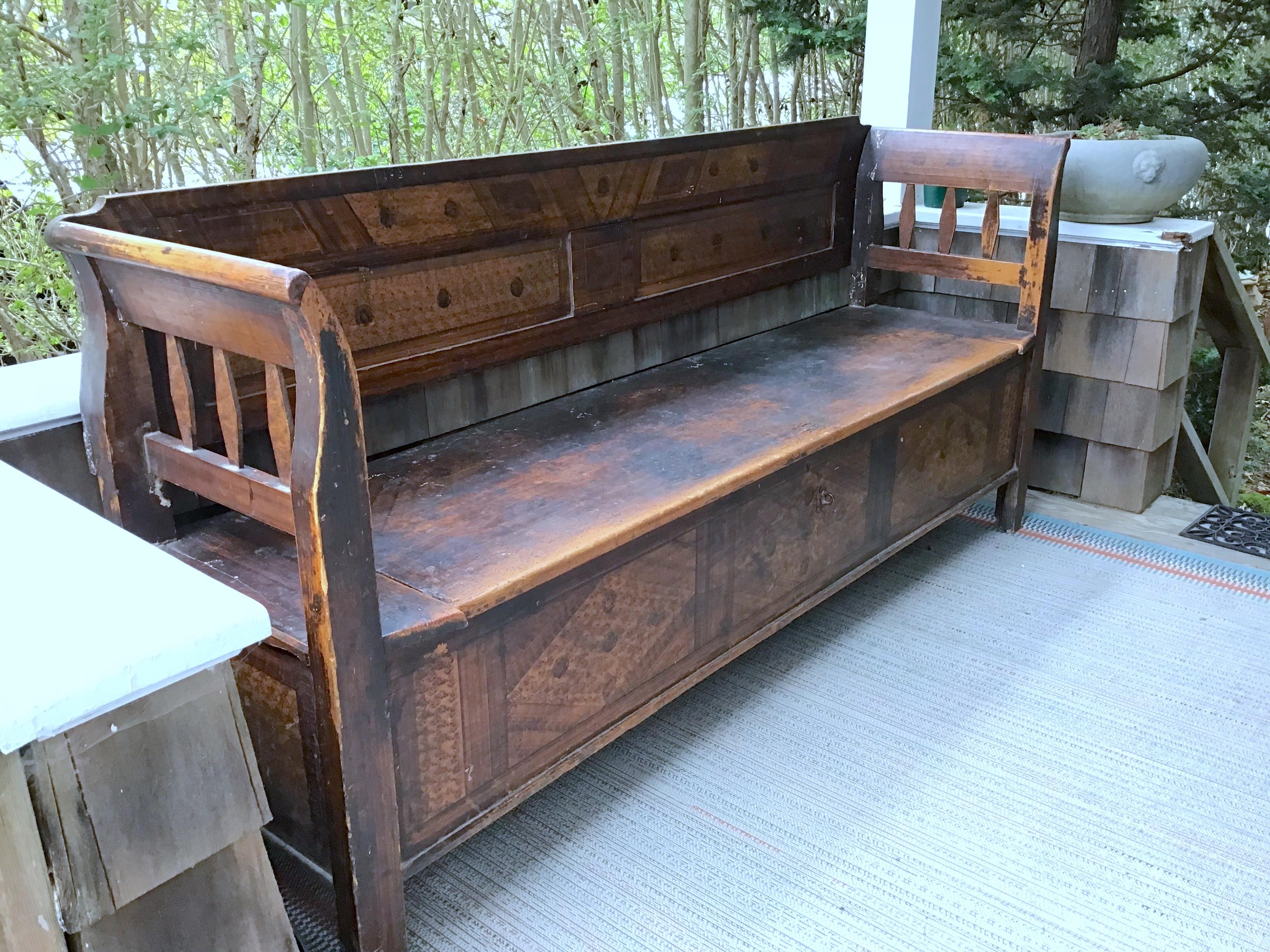 A primitive bench from the Netherlands, a faux Painted storage bench from the 19th Century, but possibly even older. Exquisite faux grain work runs along the back and front and sides. The hall bench opens for storage underneath the seat.

