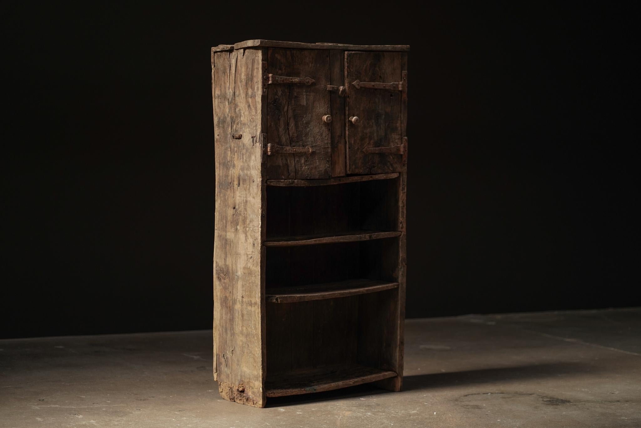 Questo armadietto per libri primitivo proveniente dal Giappone presenta una struttura in legno naturale accentuata da sottili dettagli in metallo. Con una combinazione di scaffali aperti e armadietti chiusi, dona calore, funzionalità e un fascino