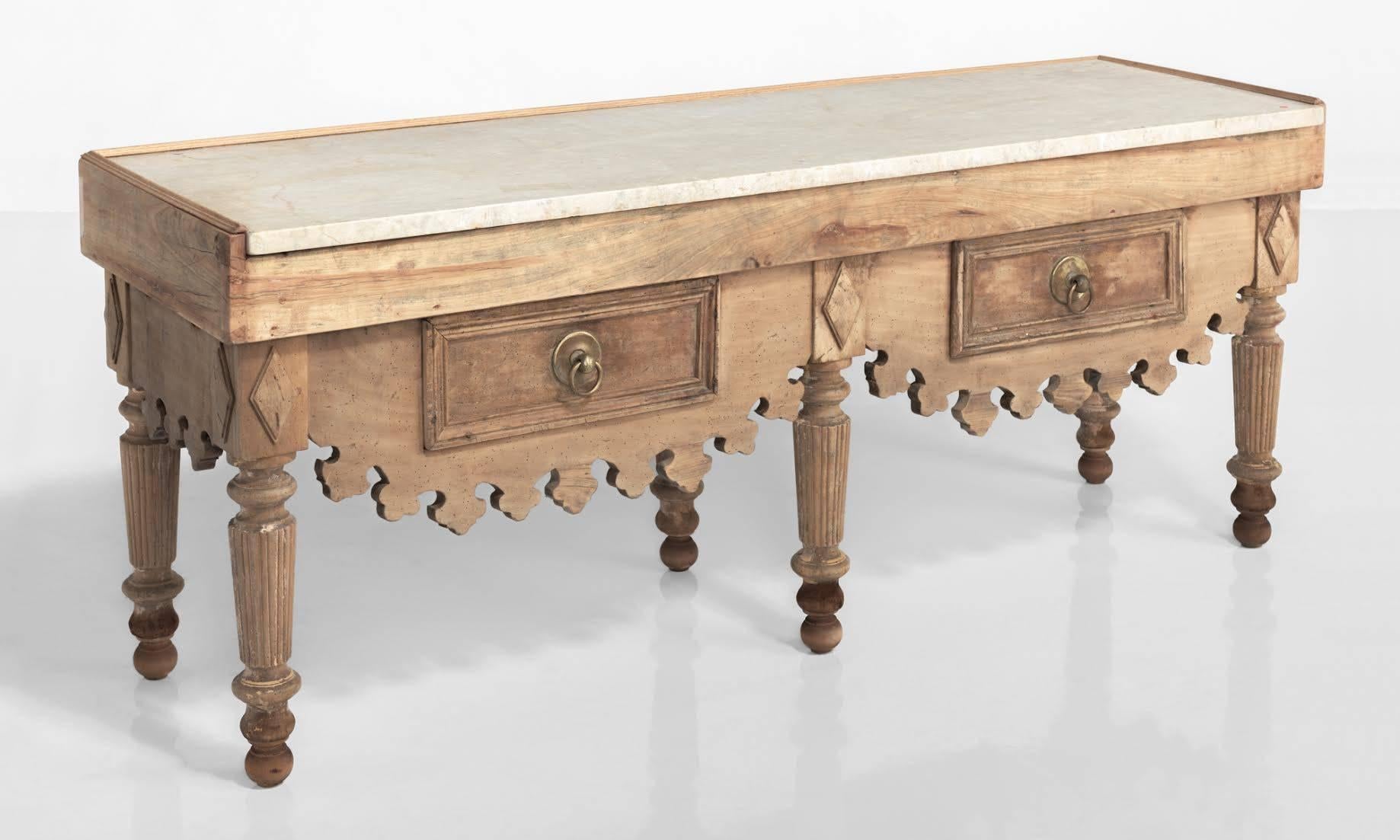 Primitive butcher block table, Spain, circa 1890

Massive form with inset marble top, generous storage, brass hardware, and an ornately carved apron.

Measures: 79