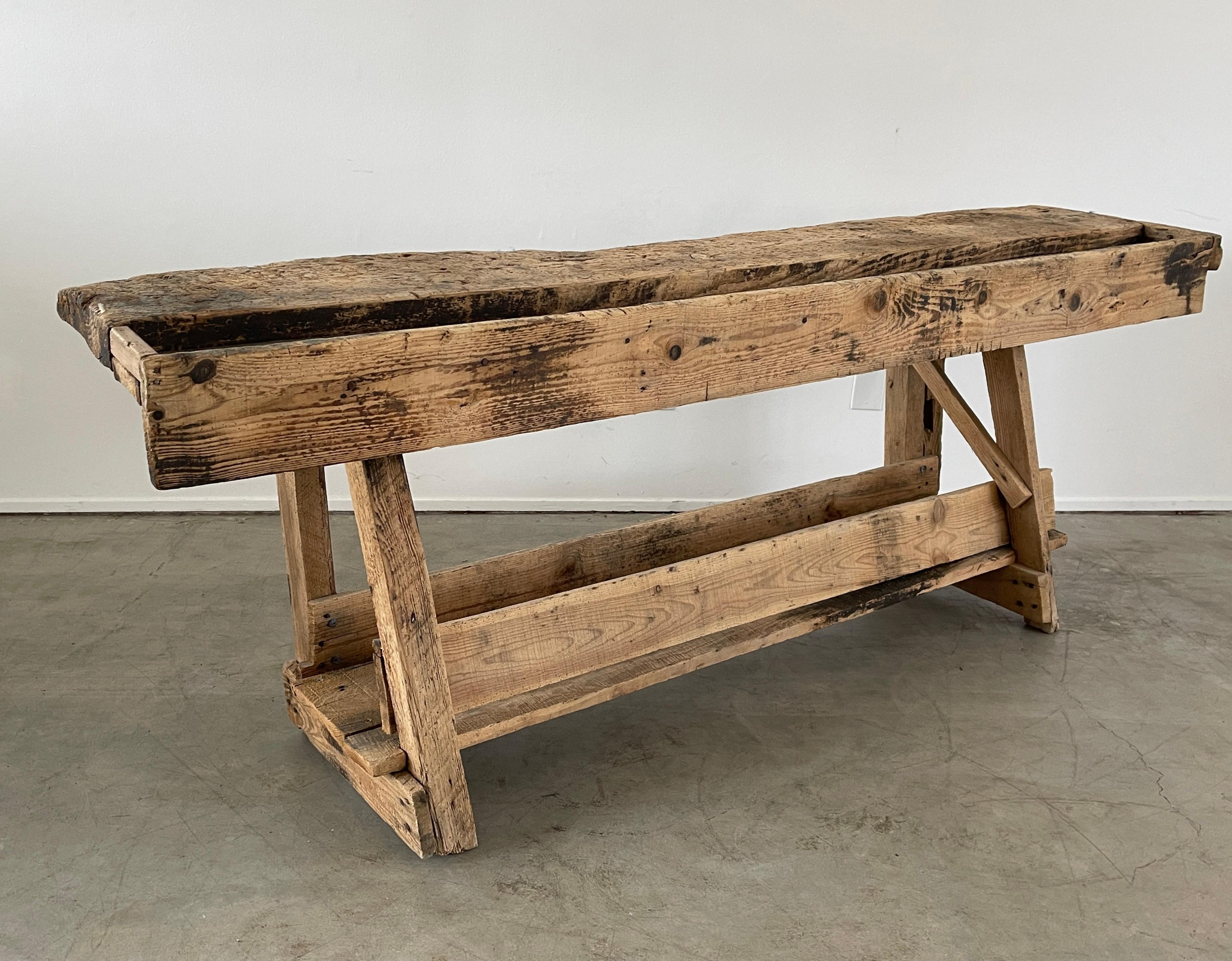 Large Brutalist carpenters bench with patina due to age in all the right places. 
Functional design with lower shelf.