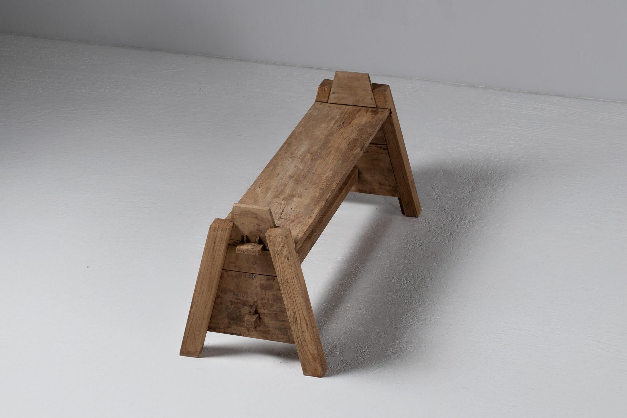 Angular and elemental, this French carpenter’s bench speaks in the quiet dialect of agrarian utility. Its silhouette—low, tapered, and architectural—evokes the austerity of a rural outbuilding, composed entirely of oak worn by decades of touch and