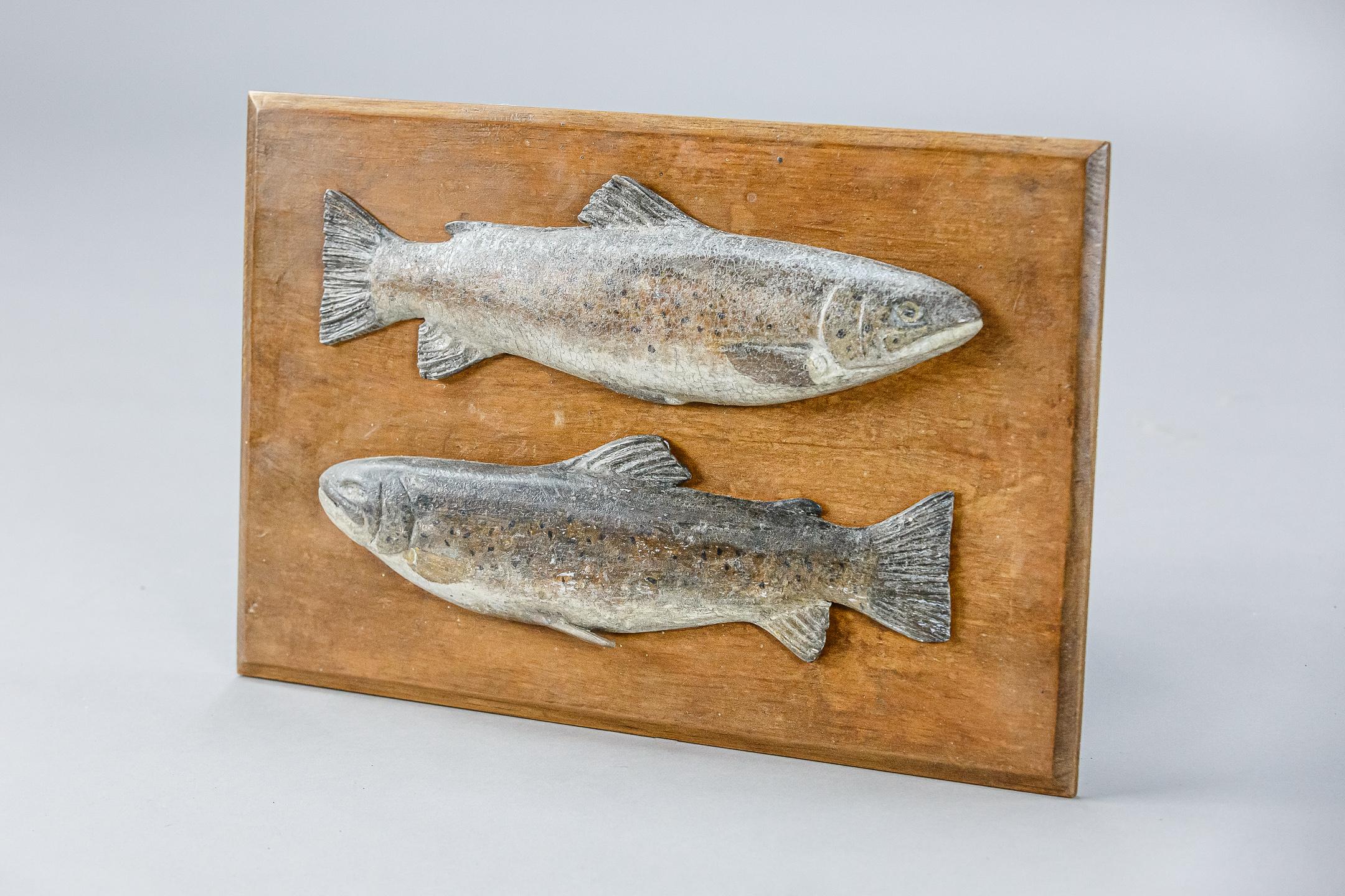 Pair of mounted carved wood and painted trophy brown trout. Unusually they are both mounted to one board. Craquelure to the painted finish. Late 20th century.