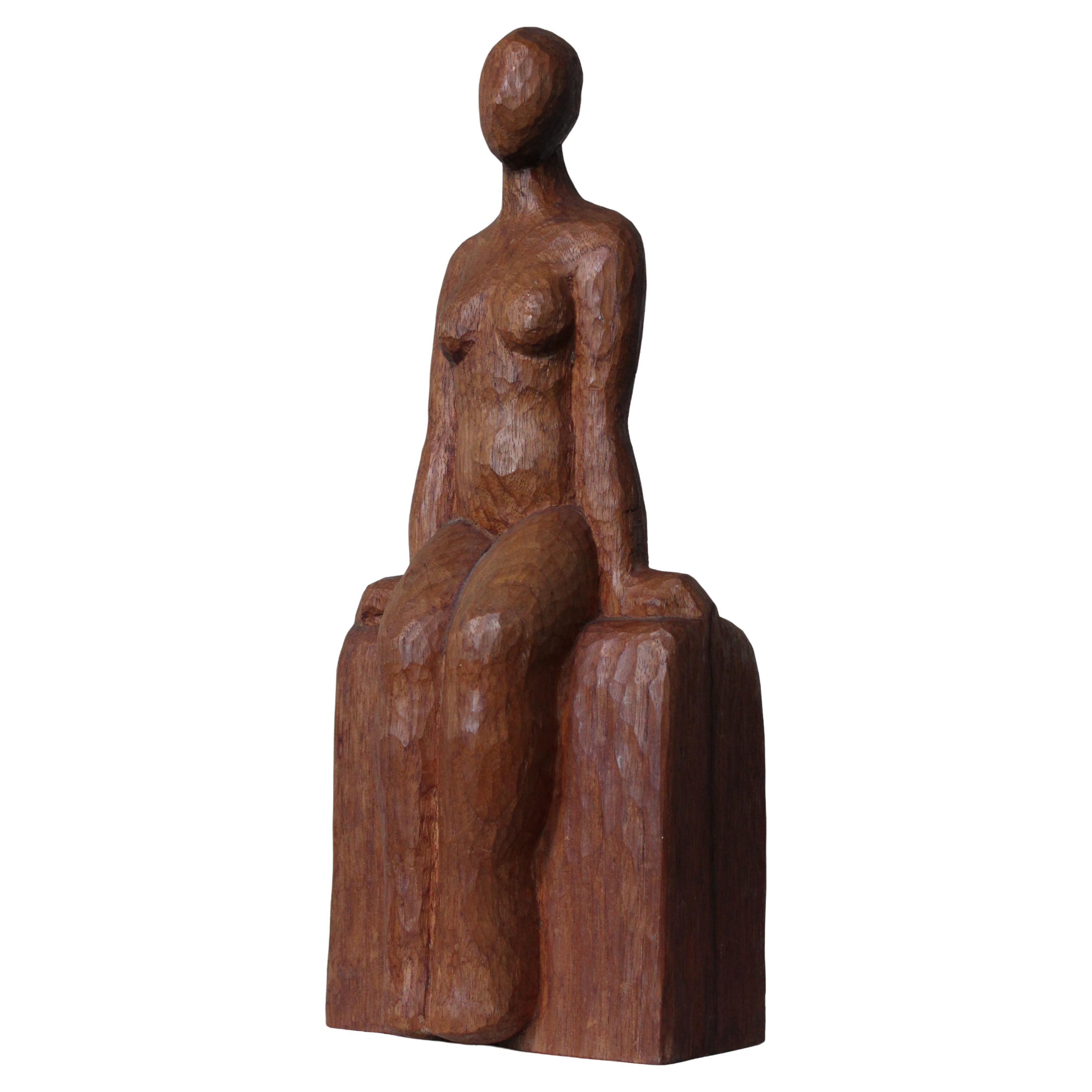 Scultura primitiva intagliata di donna seduta