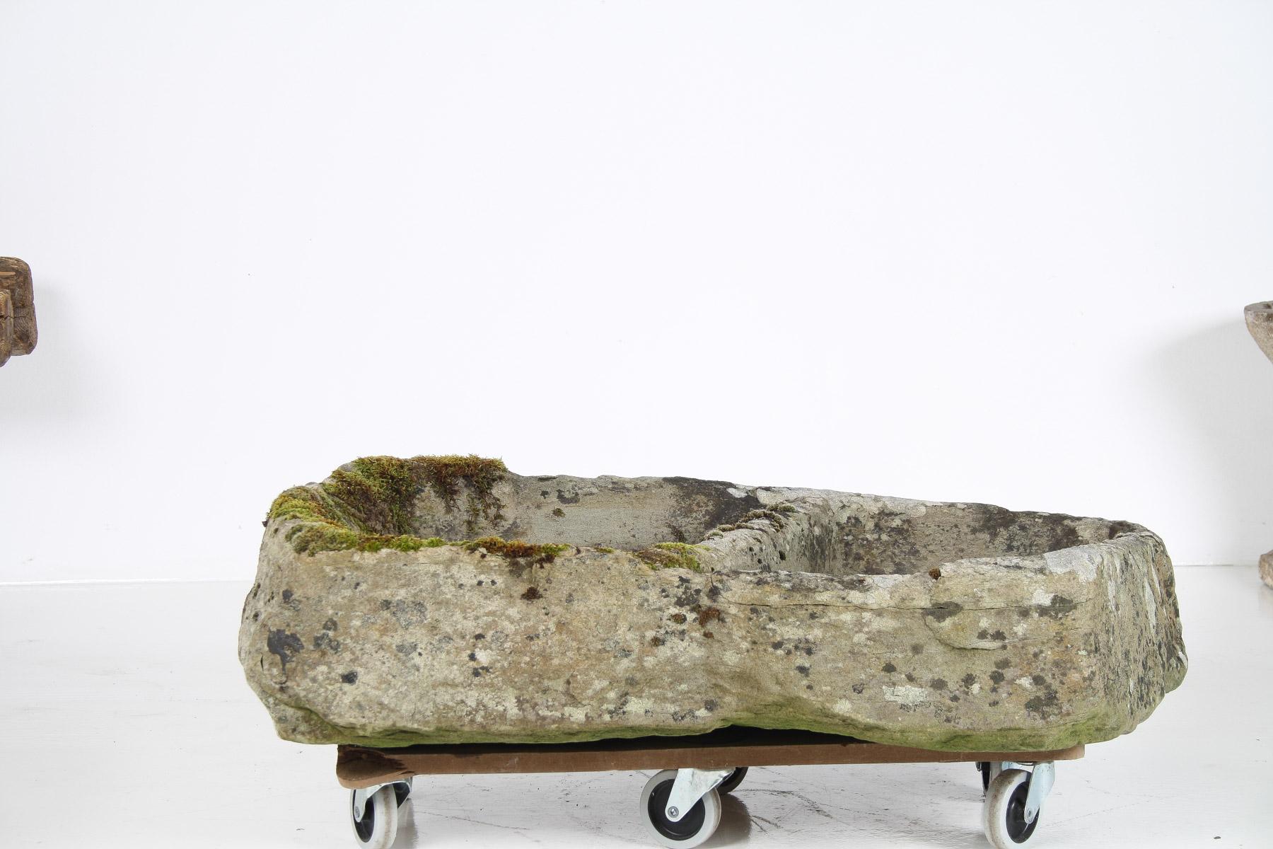 A primitive stone planter, dating back to the early part of the 19th century, possibly earlier.  Crafted from rugged sandstone, the irregular, organic shape offers a beautifully weathered appearance, with an original patina of moss and lichen that