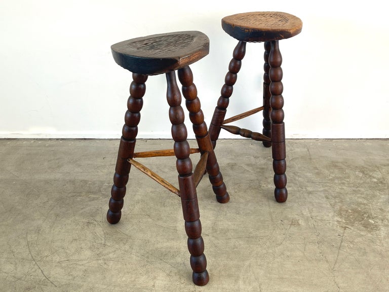 Unique barstools with thick carved wood seats and fantastic carved wood legs in the style of Charles Dudouyt.
Wonderful patina
Each stool slightly different patina and height 
Sold as a set - can be refinished to match if desired.

Darker Stool -