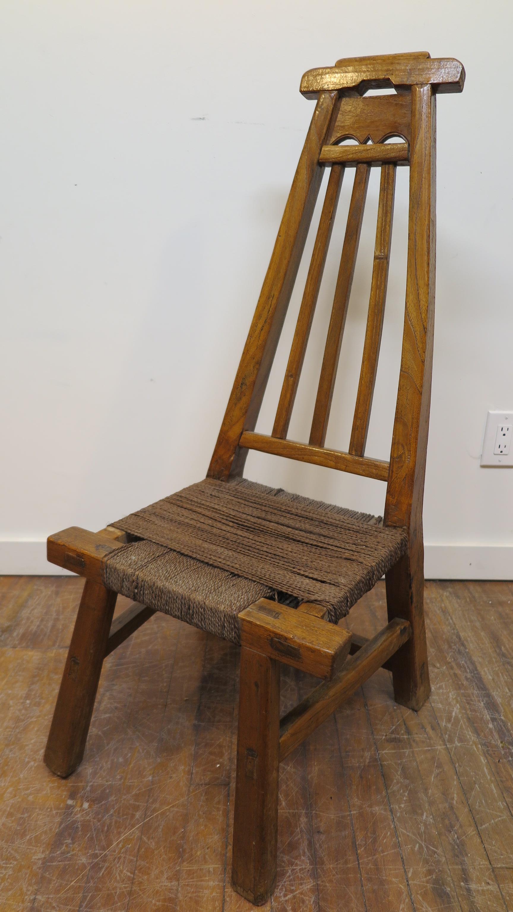 19th century Primitive fireside chair. Arched back with tall support this low chair is very comfortable. Made of hand hued hardwood and twine seat. Great for tight spaces or fireside. Measures: Seat height is 14.5 inches.