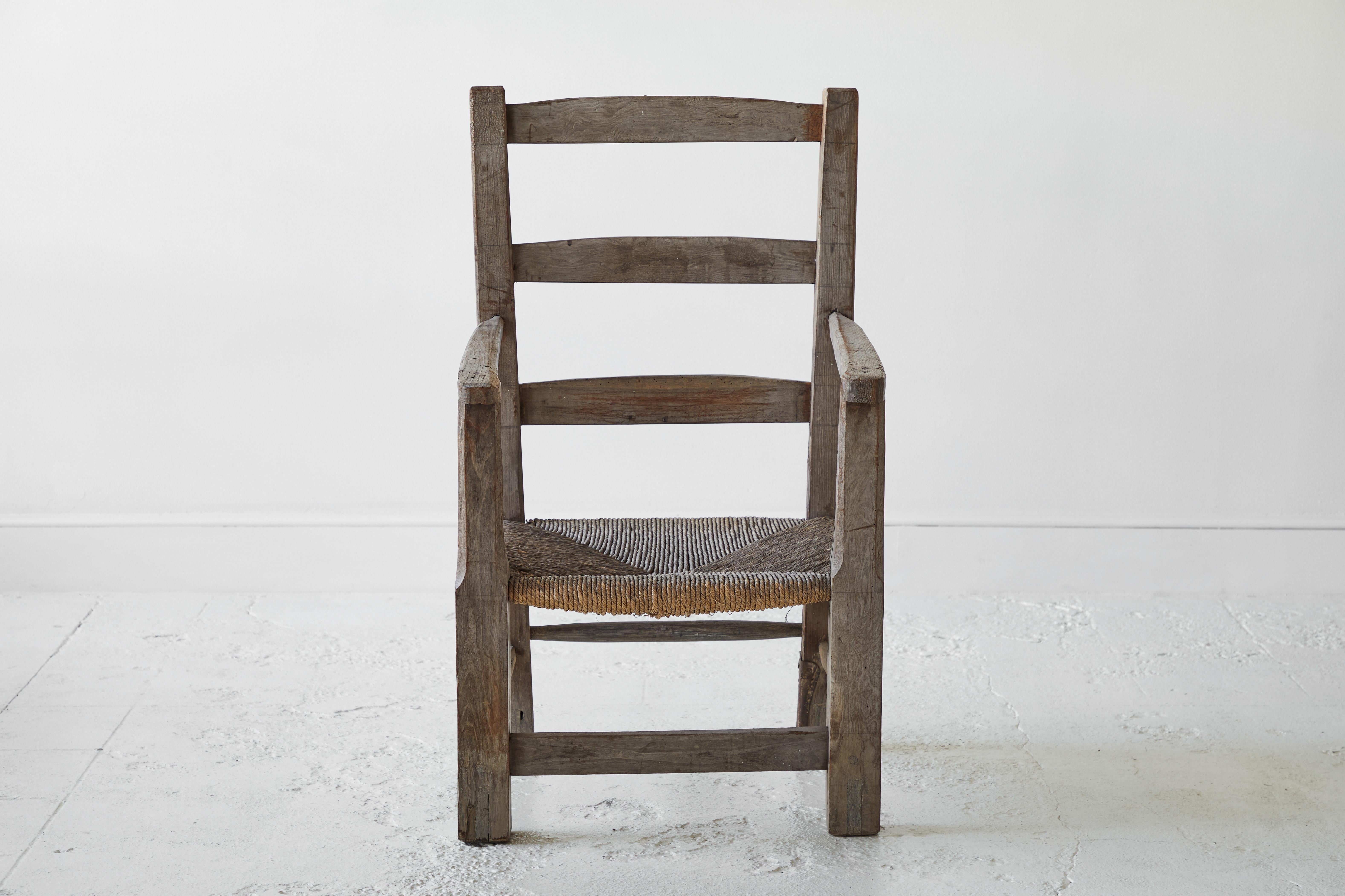 This oversized sculptural primitive chair with rush seat.