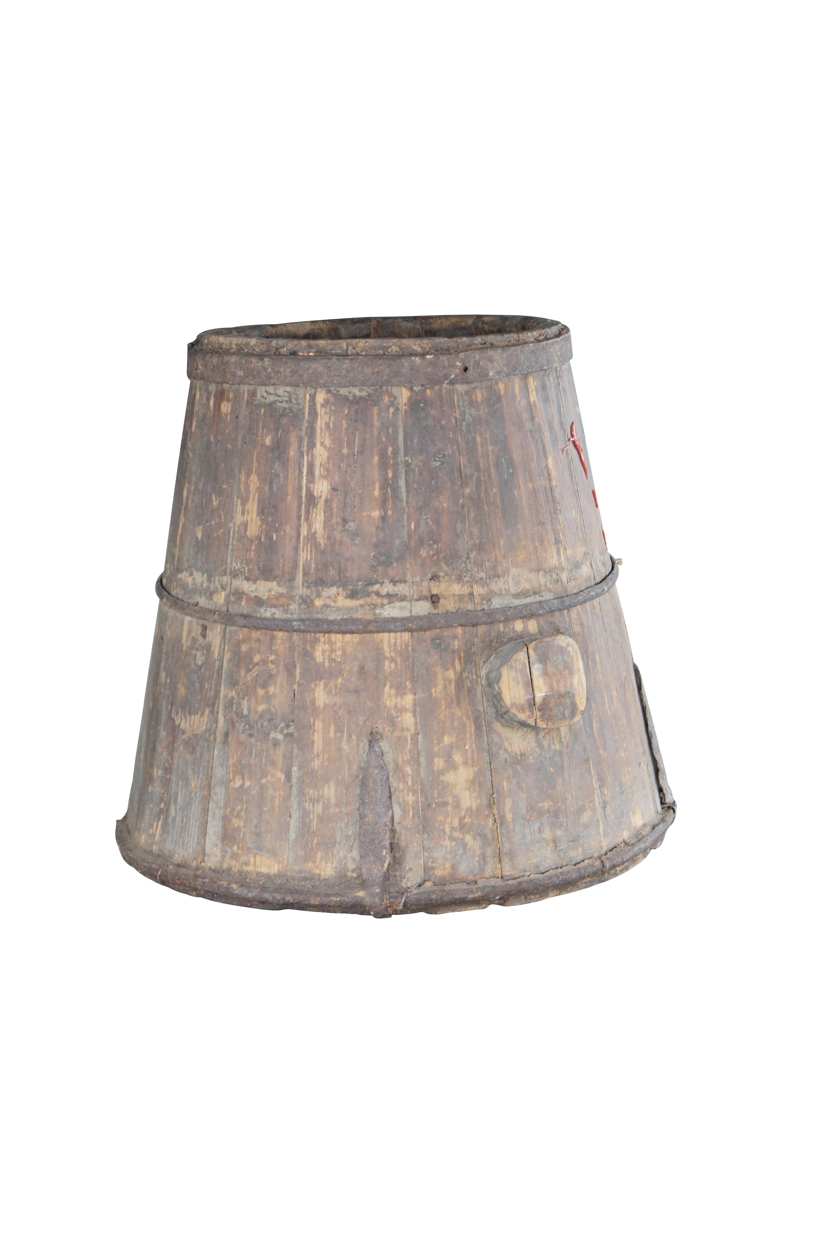 Chinese Shanxi barrel form banded iron wooden rice measure, bucket or basket. Aged with rustic patina and wax import stamp. Circa second half 20th century.

Dimensions:
16