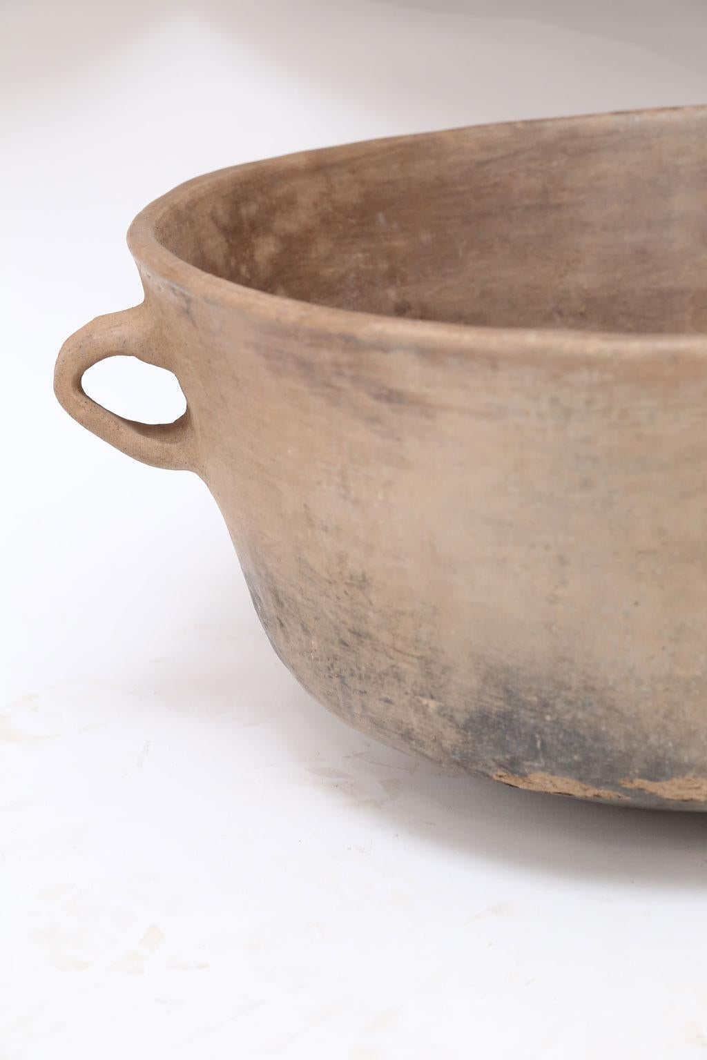 Large Primitive clay cooking bowl from Los Reyes Metzontla, Mexico. This vintage vessel is hand-sculpted, created and used circa 1950 by the indigenous population of the isolated Mexican highlands of Puebla (Zapotitlán). Exhibiting a nice rich