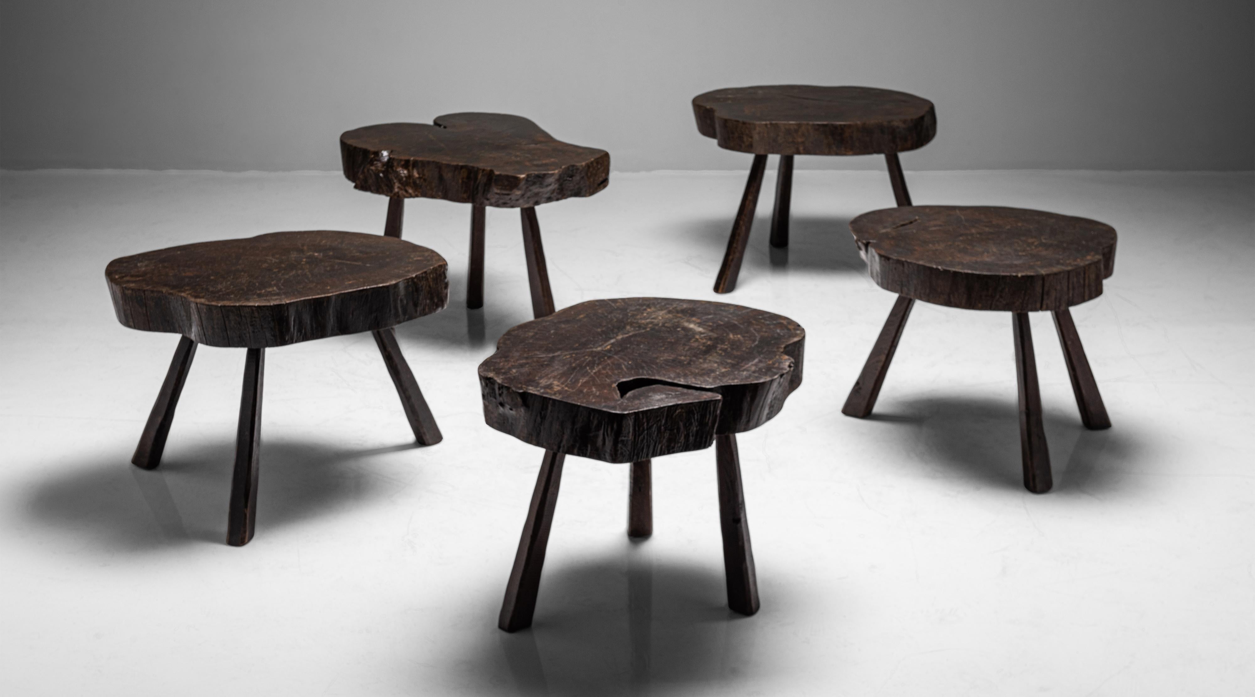 Slab top tables on three splayed legs. Original dark finish.