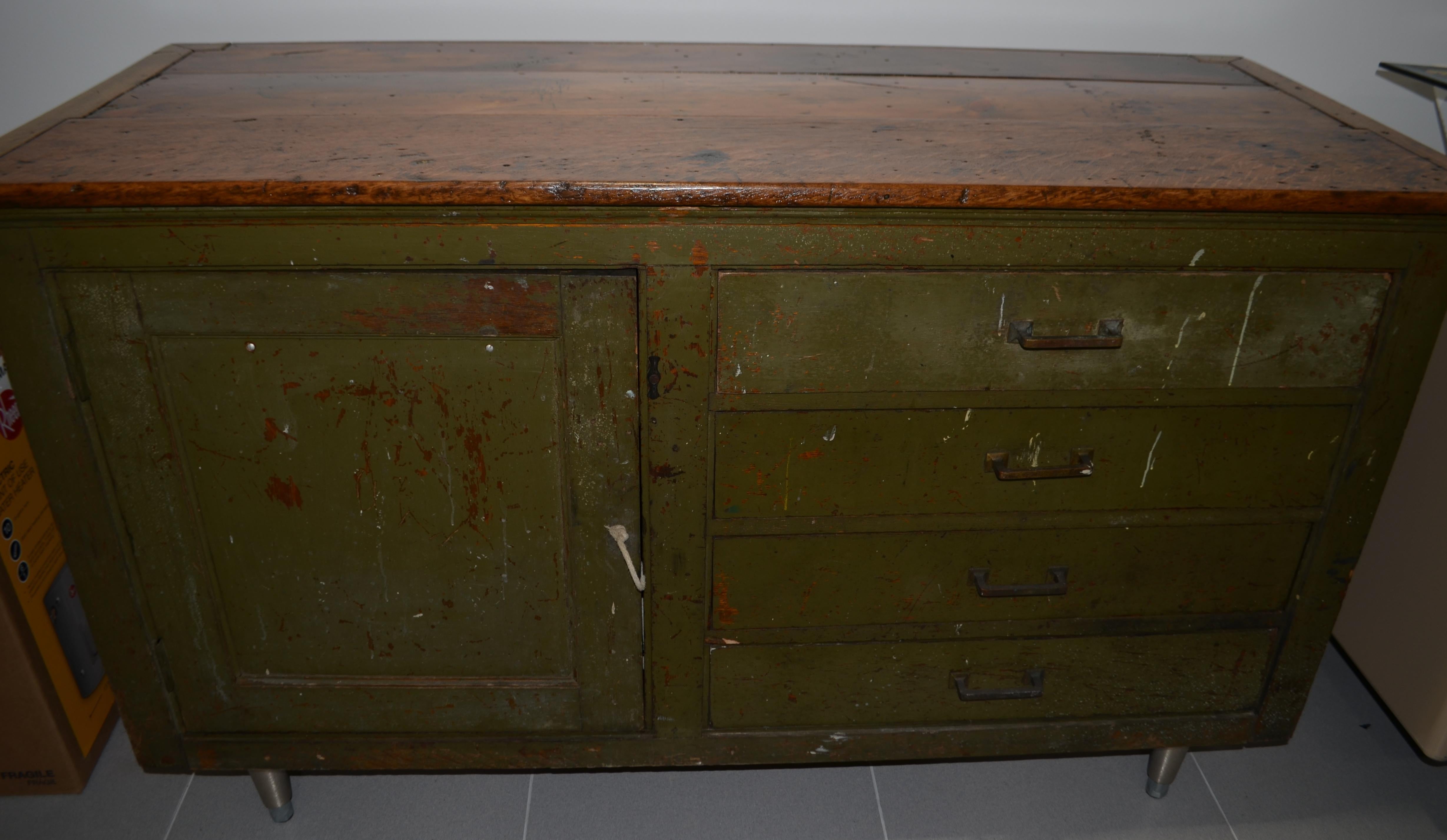 Primitive cabinet with four drawers built in along with storage cabinet. Original earthen green color plus softly worn and richly mahoganized pine top. Good storage space behind door plus four drawers. Original pull cord. Steel legs added. Would