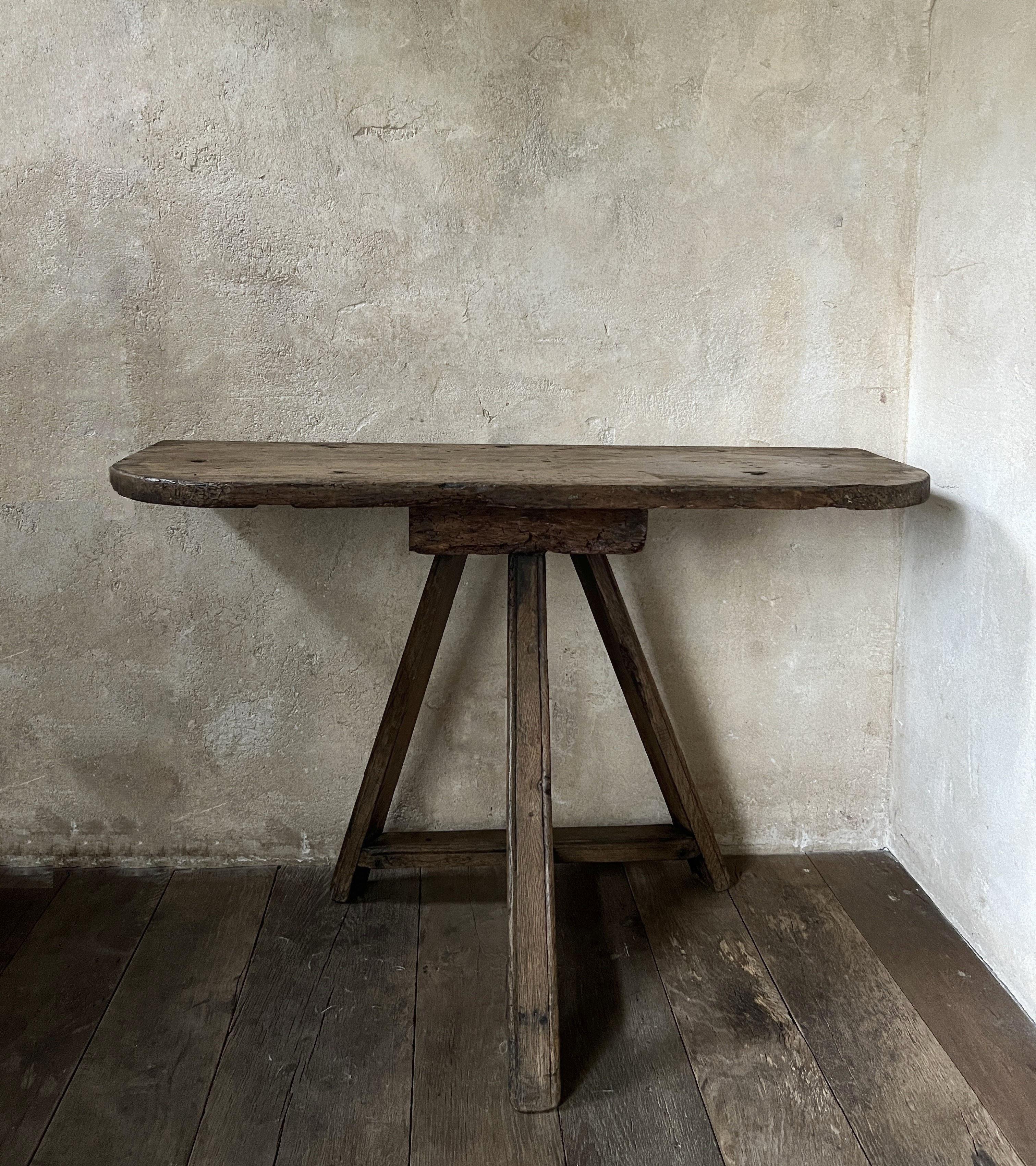 A 19th century sidetable with a solid one slab pine top on a oak trestle base.  Most likely made by rural craftsmen with bits and pieces they found on their land. This kind of primitive furniture was made to use troughout the house for different