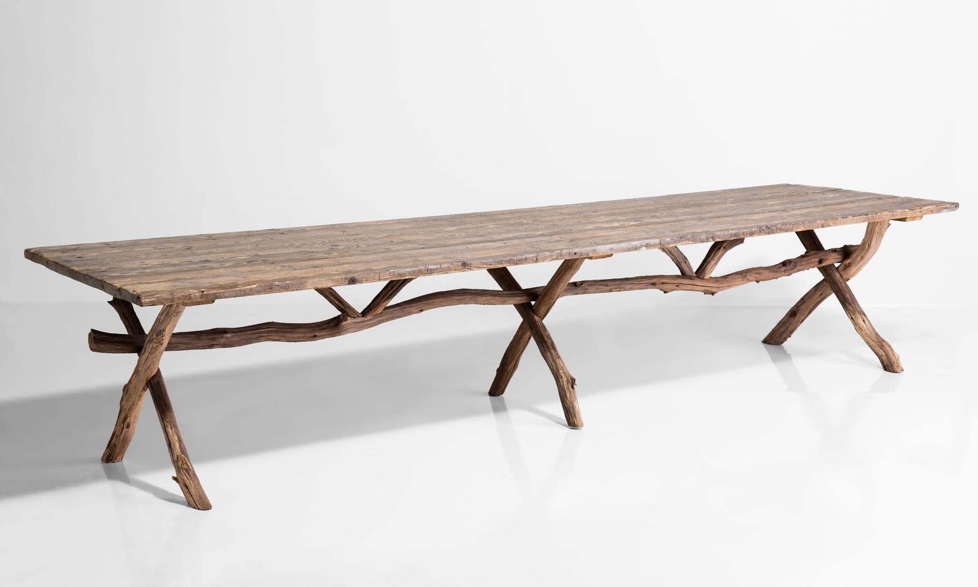 Primitive dining table, France, circa 1900.

Pine plank top with tree branch base.