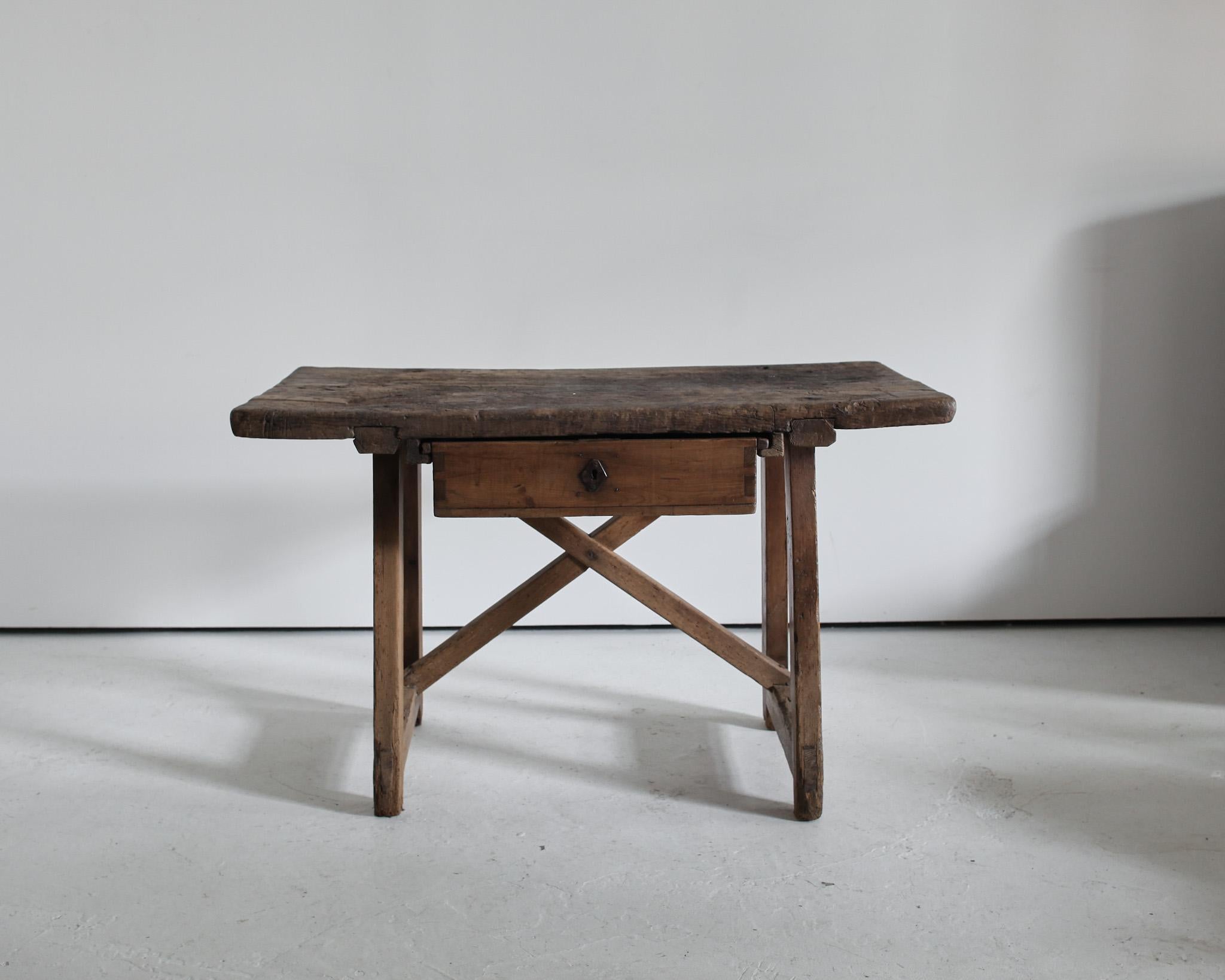 An early 19th century Catalan work/side table from the Pyrenees.

Thick, heavily worn single slab oak top on “X” frame pine base.

Single pine drawer.