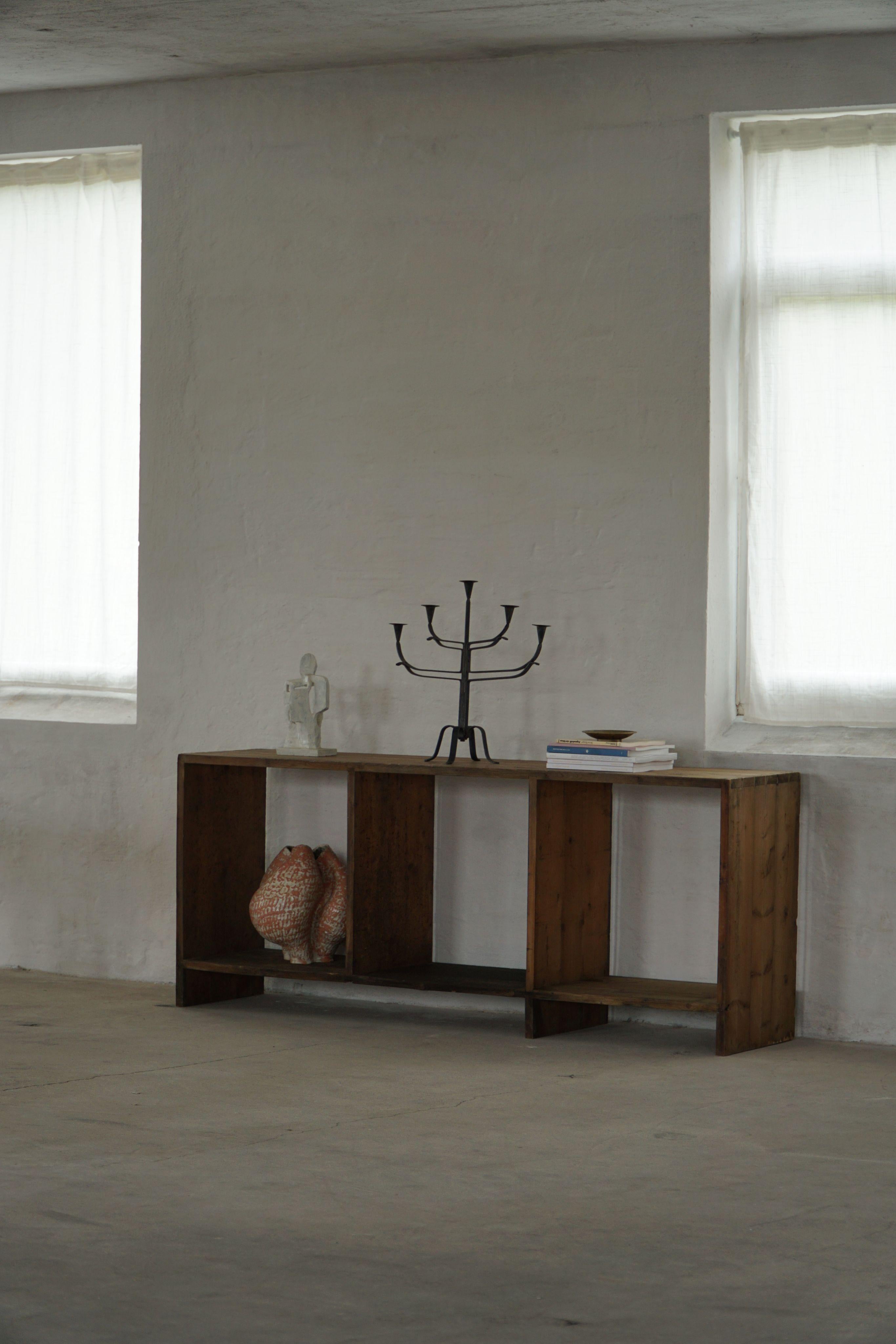 This striking three-bay bookcase, crafted from solid oak, features a warm, rich patina that highlights the wood’s natural grain and age. Generous in scale and presence, its bold, architectural form evokes the spirit of Pierre Jeanneret’s elegance,