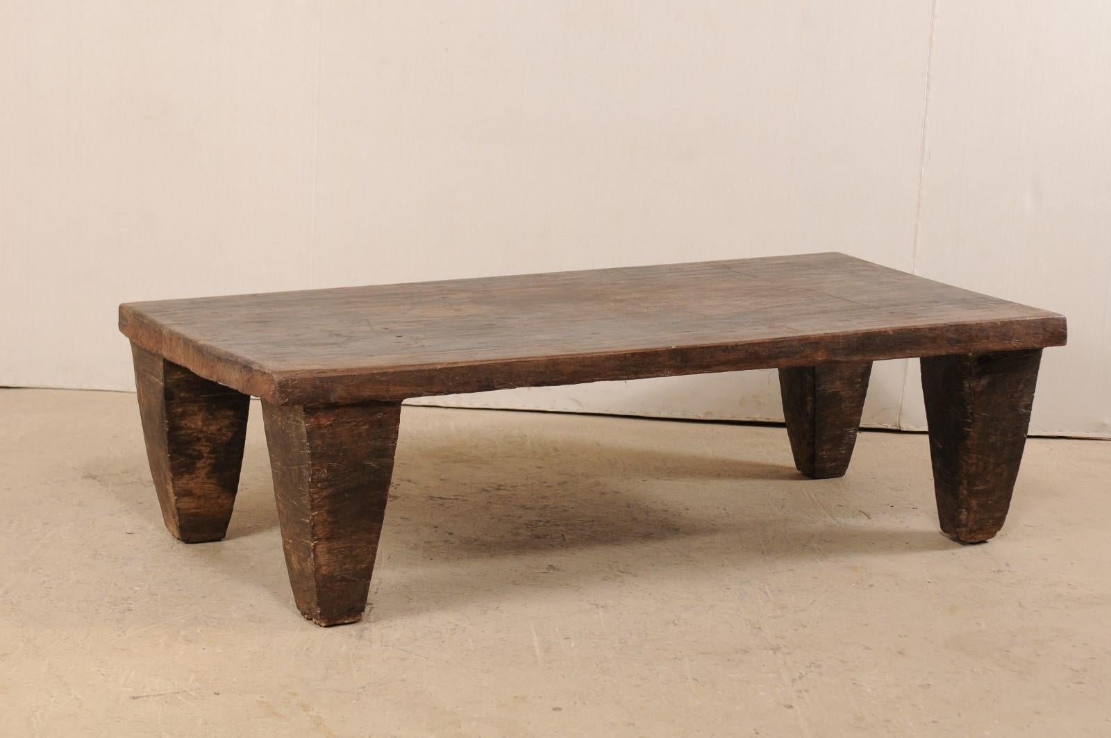 A primitive wood Naga daybed, or coffee table, from the early 20th century. This wooden bed from the Naga tribes of Nagaland, North East India has been carved out of a single log and would make for a great coffee table and conversational piece. This