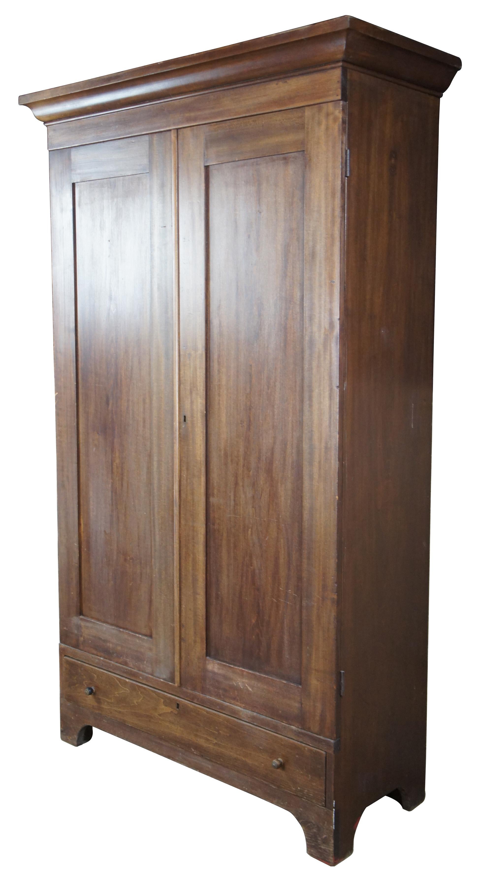 Primitive early American farmhouse style clothing armoire. Made of walnut, featuring a hanging bar and one central lower drawer, circa 1870s. Measure: 84