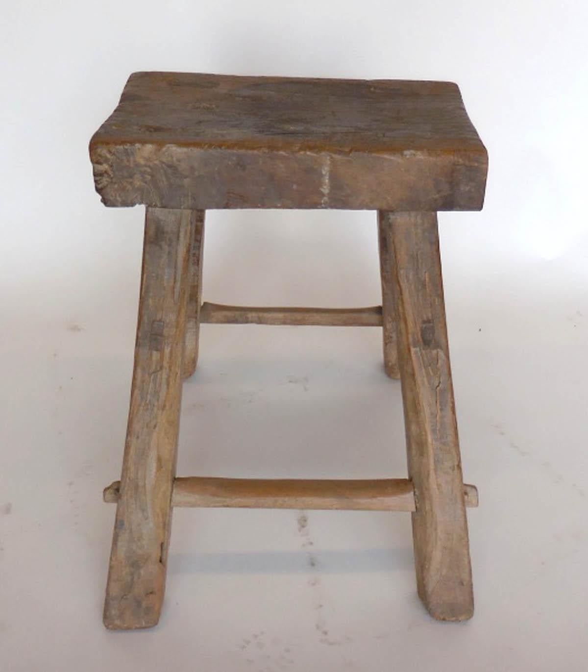 Antique Chinese rustic elm wood stool with flared legs. Mortise and tenon construction. Great old weathered patina. The seat measures 17.25 by 11 by 3 inches thick.