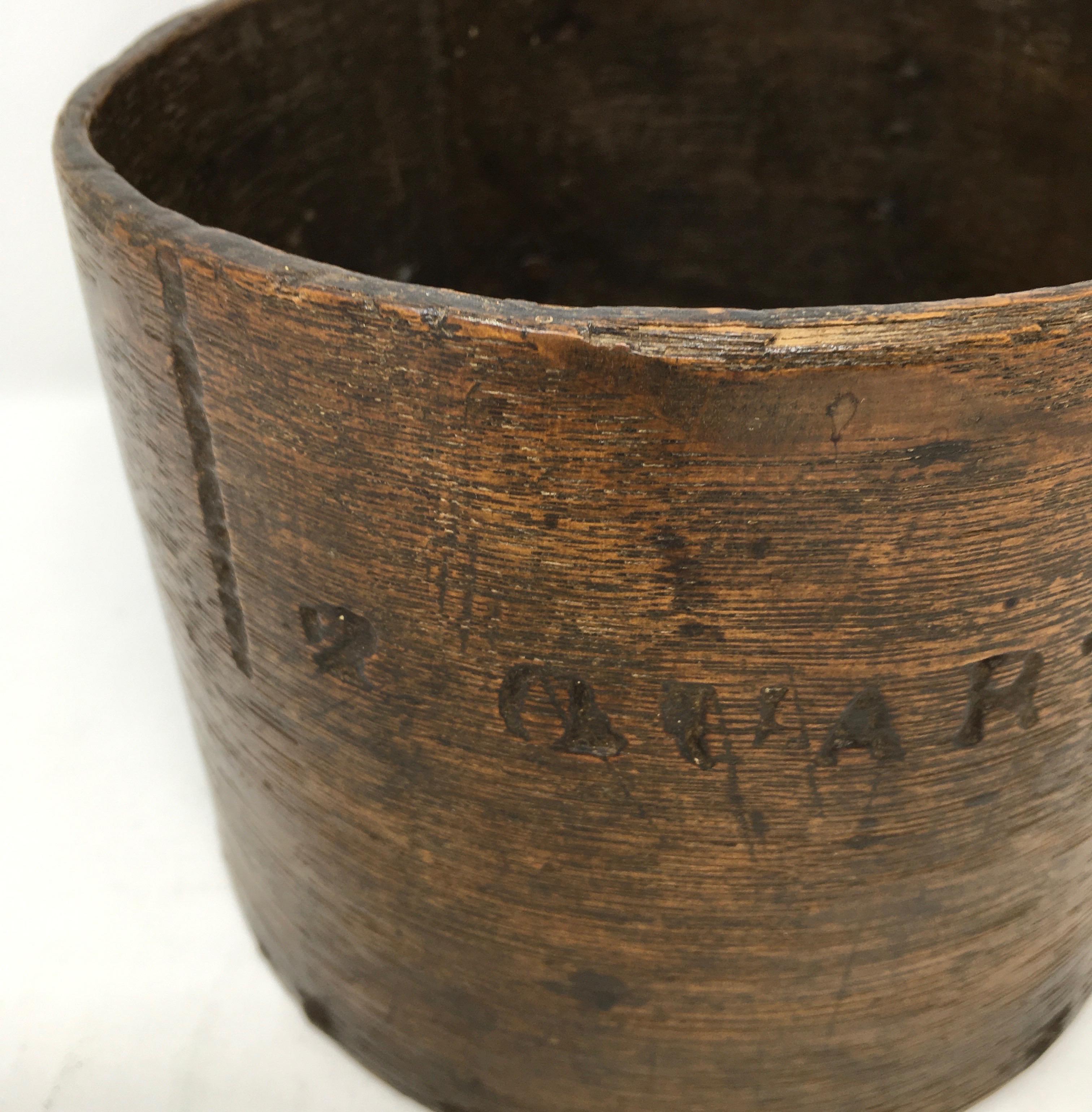 Found in England, this 19th century Primitive two quart grain measure is made with a single piece of wood bent into a barrel shape secured by tiny rivets around a round bottom piece of wood. The piece has fabulous aged wood patina and would be great