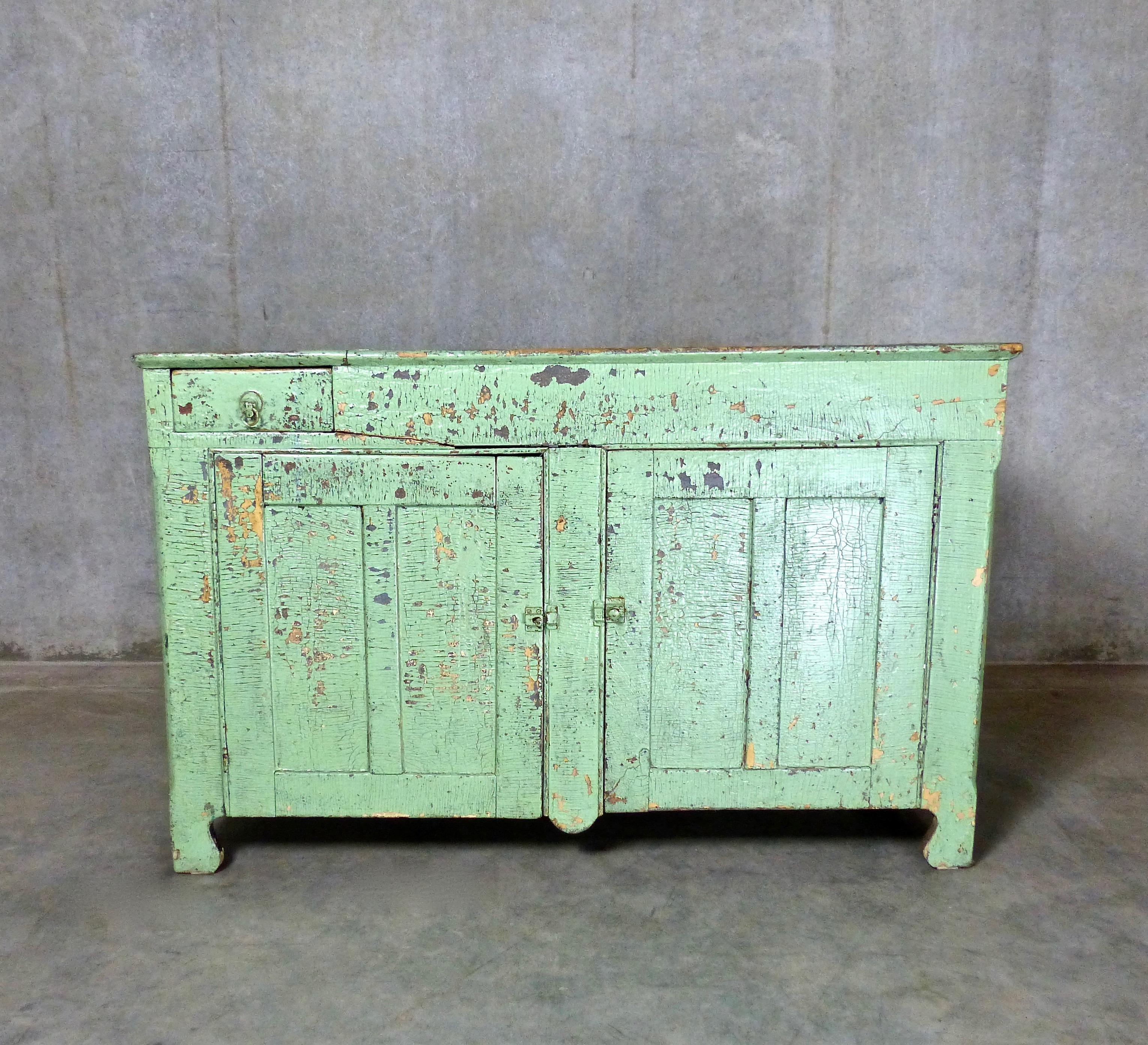 Ontario dry sink in original bright green polychrome paint, circa 1870. This piece has an untouched, sealed, aged cracked surface.
Features shelves behind cabinet doors plus one small drawer.
Excellent as a bar or serving station. Dimensions: 31