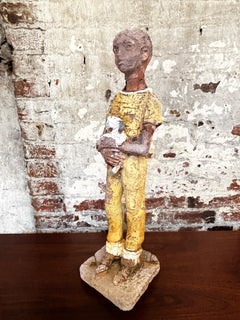 Primitive figure of a boy holding dog