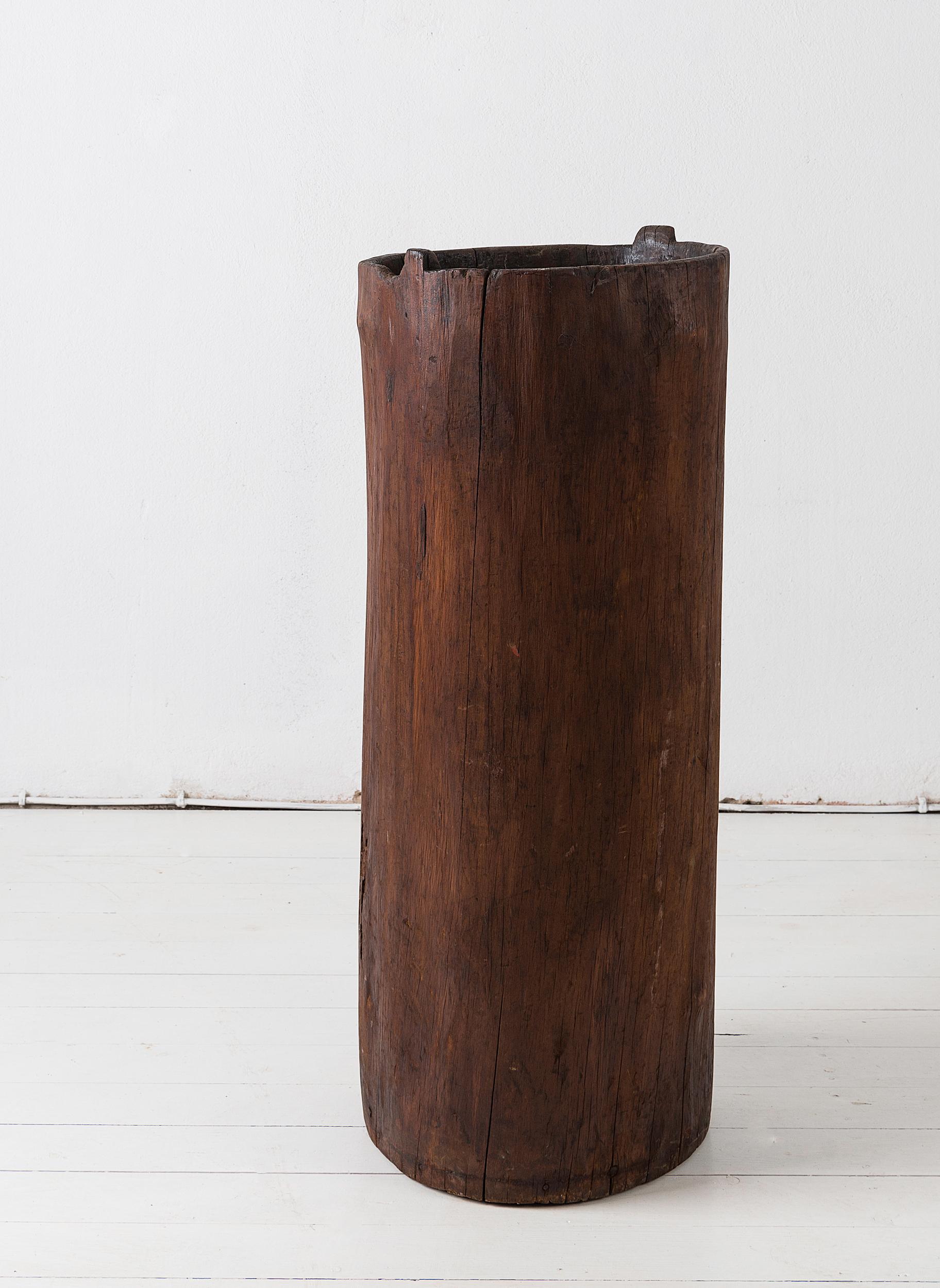 An early 19th century large grain storage barrel, carved from a whole tree trunk, of natural tapering cylindrical form. 
Perfect for use as a planter or for walking sticks and umbrellas, or just as beautiful, organic sculpture in a modern or