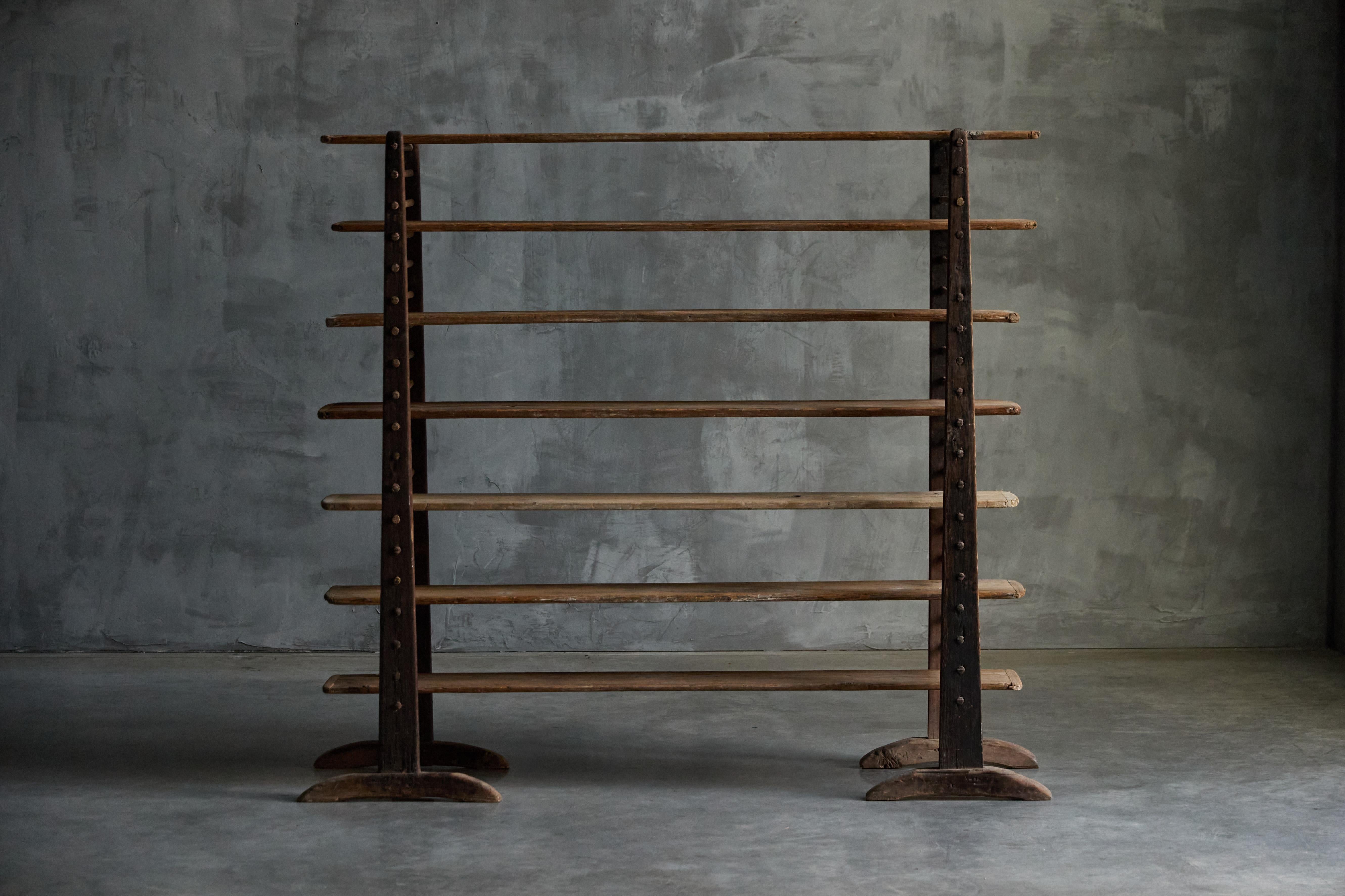 Rustic wooden folk art bread rack from 19th century France reminiscent of days gone by. This bakery rack features seven spacious shelves, making it not only a functional storage solution, but also a beautiful showpiece that captures the hearts of