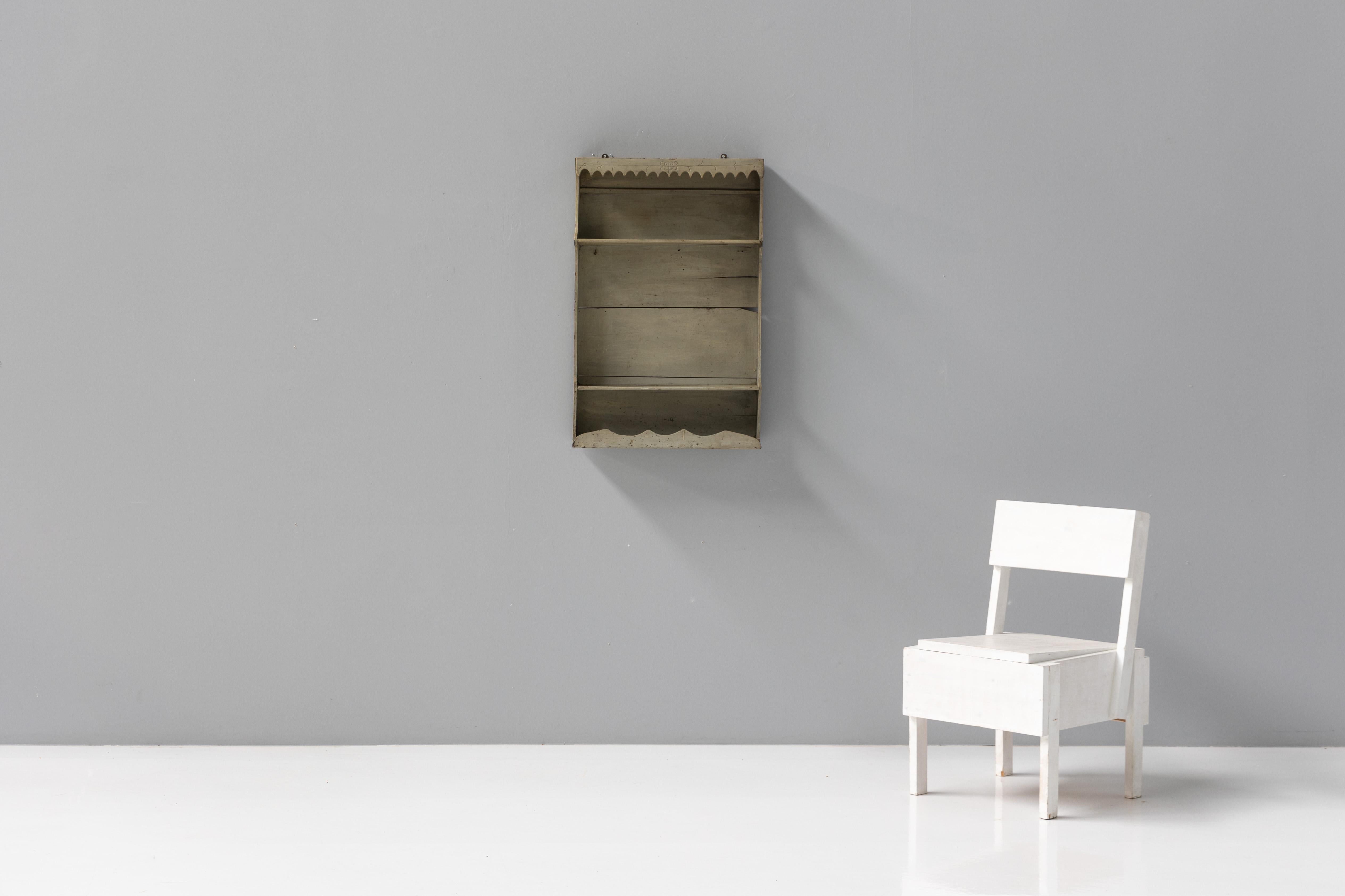 19th-century French handmade painted wall shelf, crafted with primitive charm and adorned with curvy side brackets and intricate carving. This unique folk art shelf is as functional as it is beautiful. Perfect for displaying curios, small