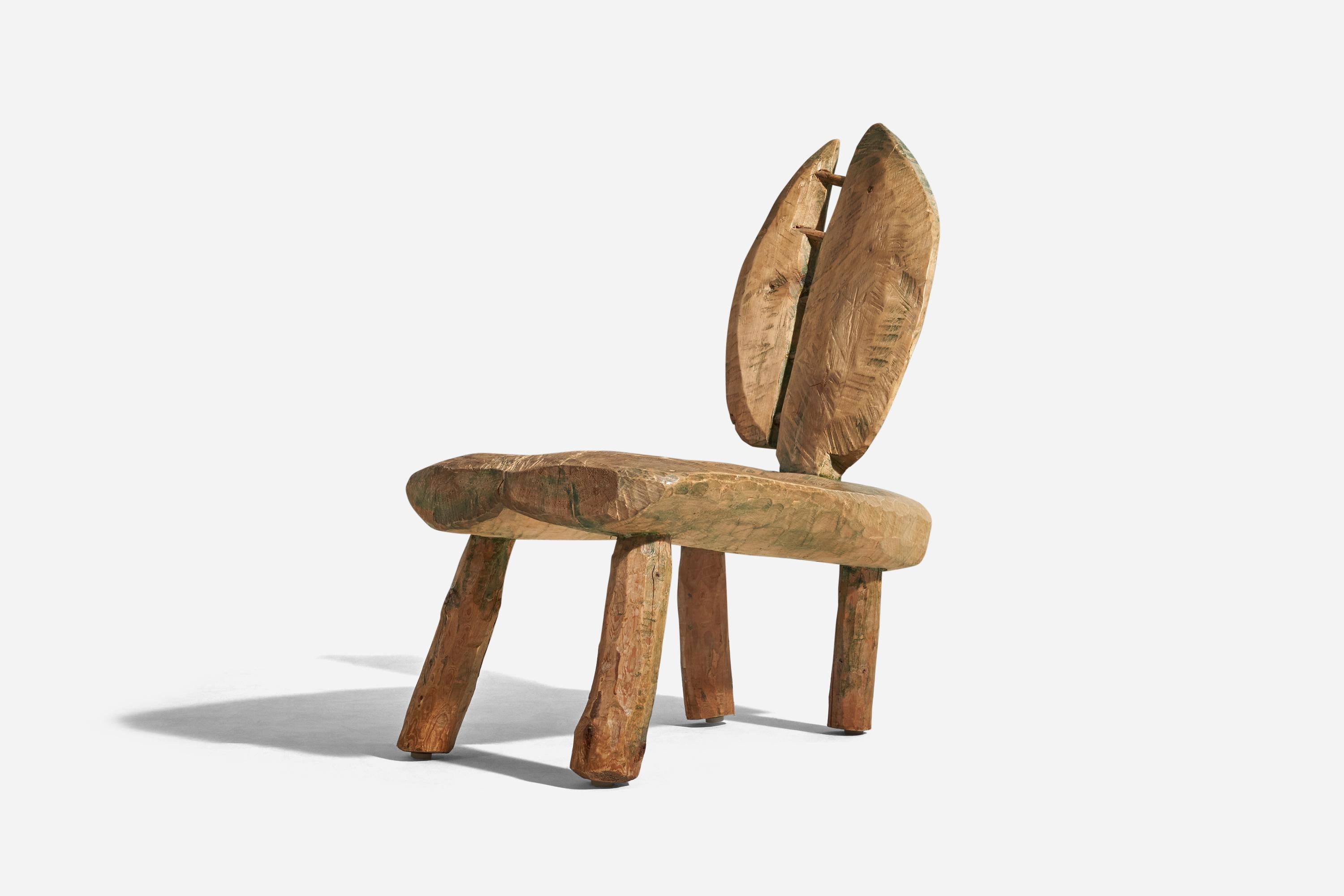 A sculpted painted wooden, primitive freeform lounge chair designed and produced in Sweden, circa 1960s. 
