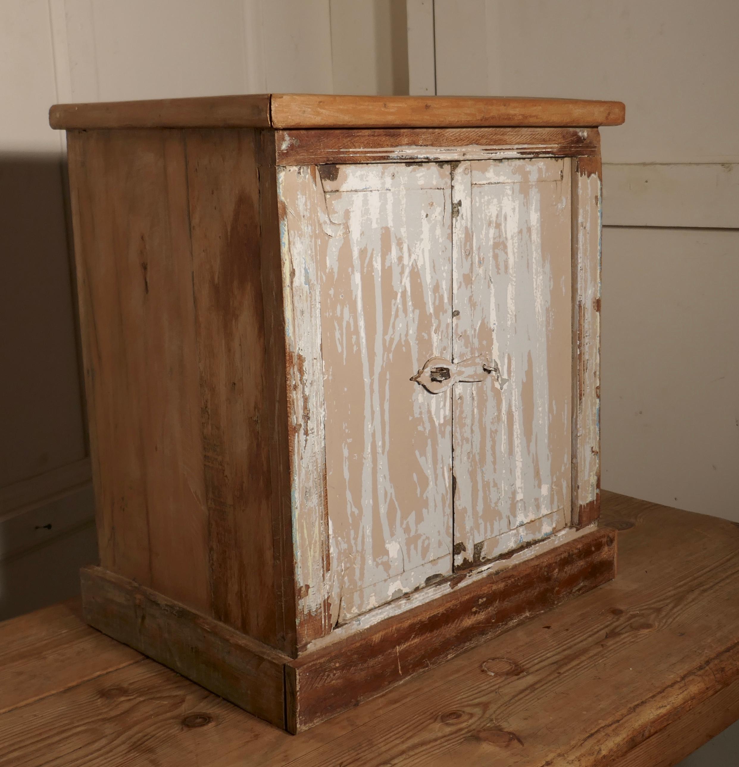 Primitive French rustic 2-door cupboard with distressed worn paint

The is a deceptively heavy piece, it is made in solid hardwood and has some original metal fittings, it comes from the south of France
The cabinet stands on a small plinth, the