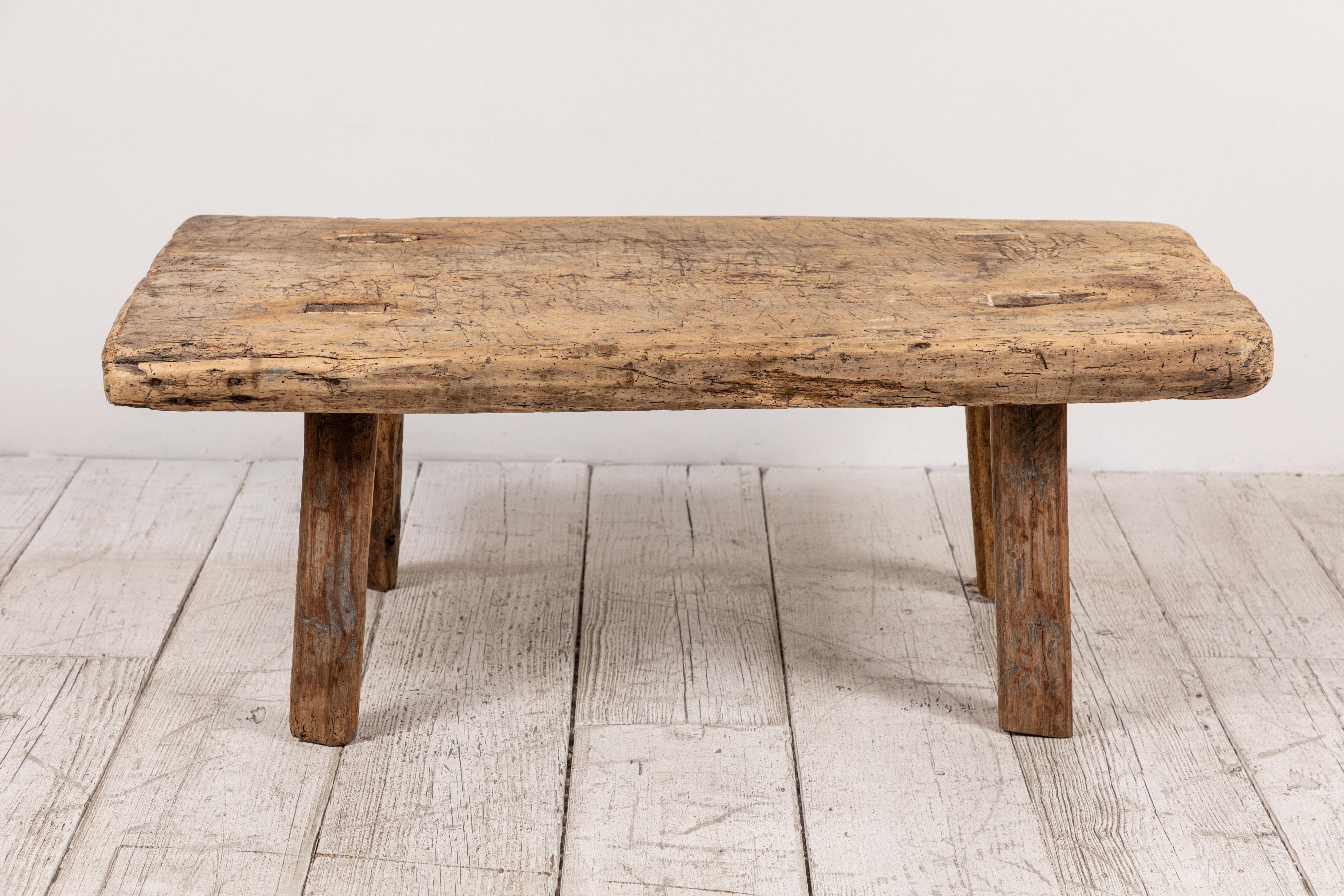 Primitive French wooden table with four splayed legs. The wood is old and offers unique grain.