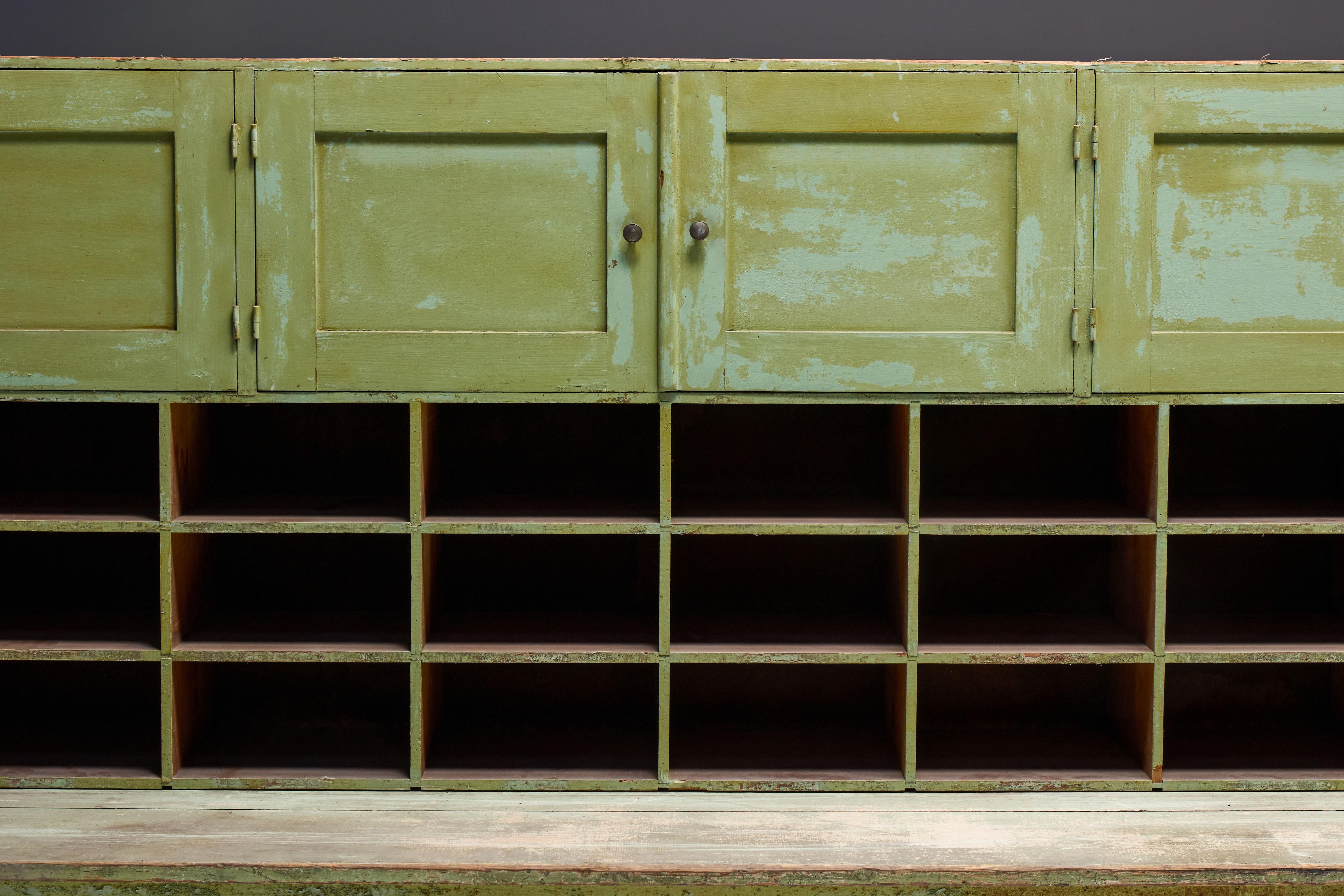 Apothekerschrank aus dem 19. Jahrhundert mit originaler grüner Patina, die bis zur Perfektion abgenutzt ist. Die vielen Fächer und geräumigen Unterschränke des Schranks bieten praktischen Stauraum, der sich sowohl für moderne als auch für