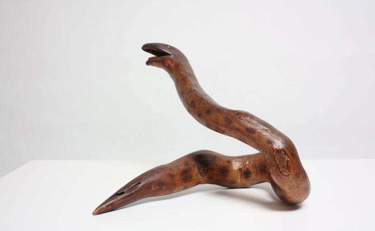 Charming Primitive / Folk Art snake carved from a dense, hollow tree branch. Wood retains its original dark stain and boasts nice texture and detail. Minimal wear from age and use (spots of loss to finish and white paint speckles throughout). 
 