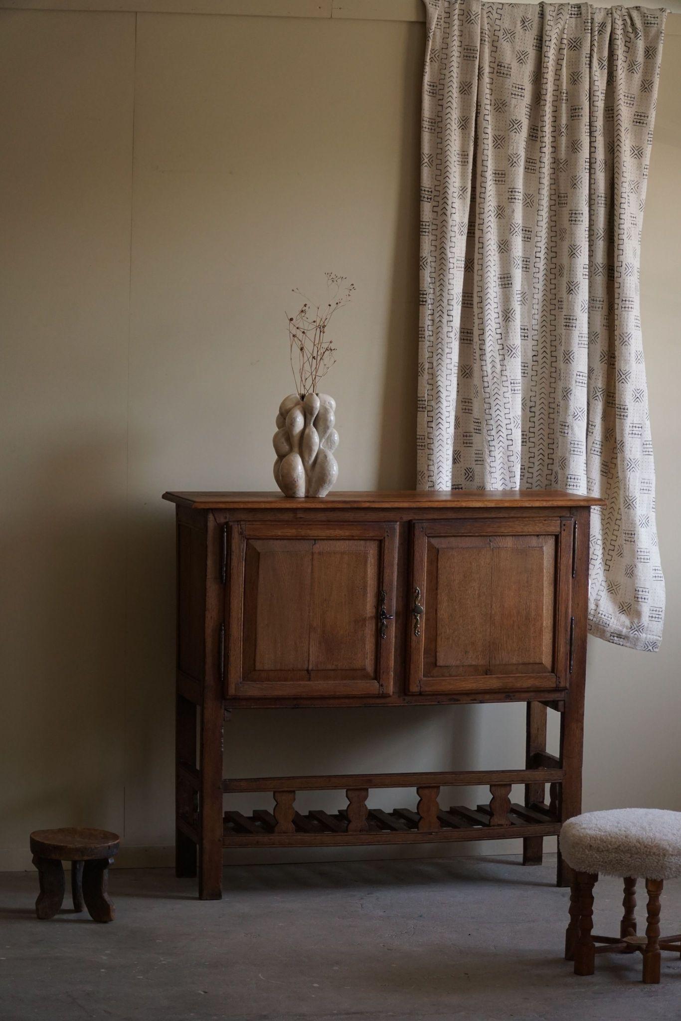 Un affascinante mobile primitivo in rovere lavorato a mano, realizzato da un ebanista francese all'inizio del XX secolo. È costruito in rovere massiccio con tecniche di falegnameria tradizionali, per garantire durata e fascino rustico. L'armadio