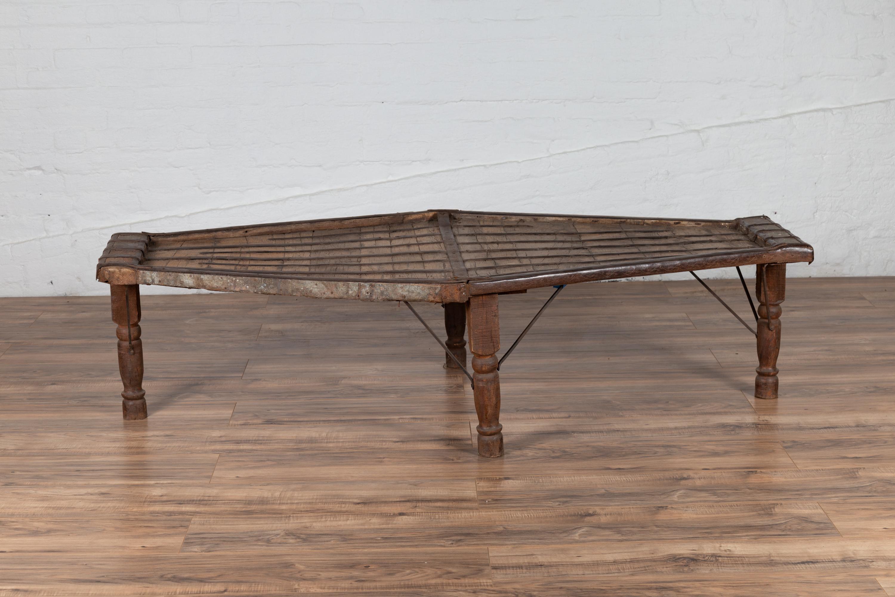 An antique Indian bullock cart coffee table from the early 20th century, originally used to carry goods. We have three similar table available, all with slight variations. Born in India during the early years of the 20th century, this rustic coffee