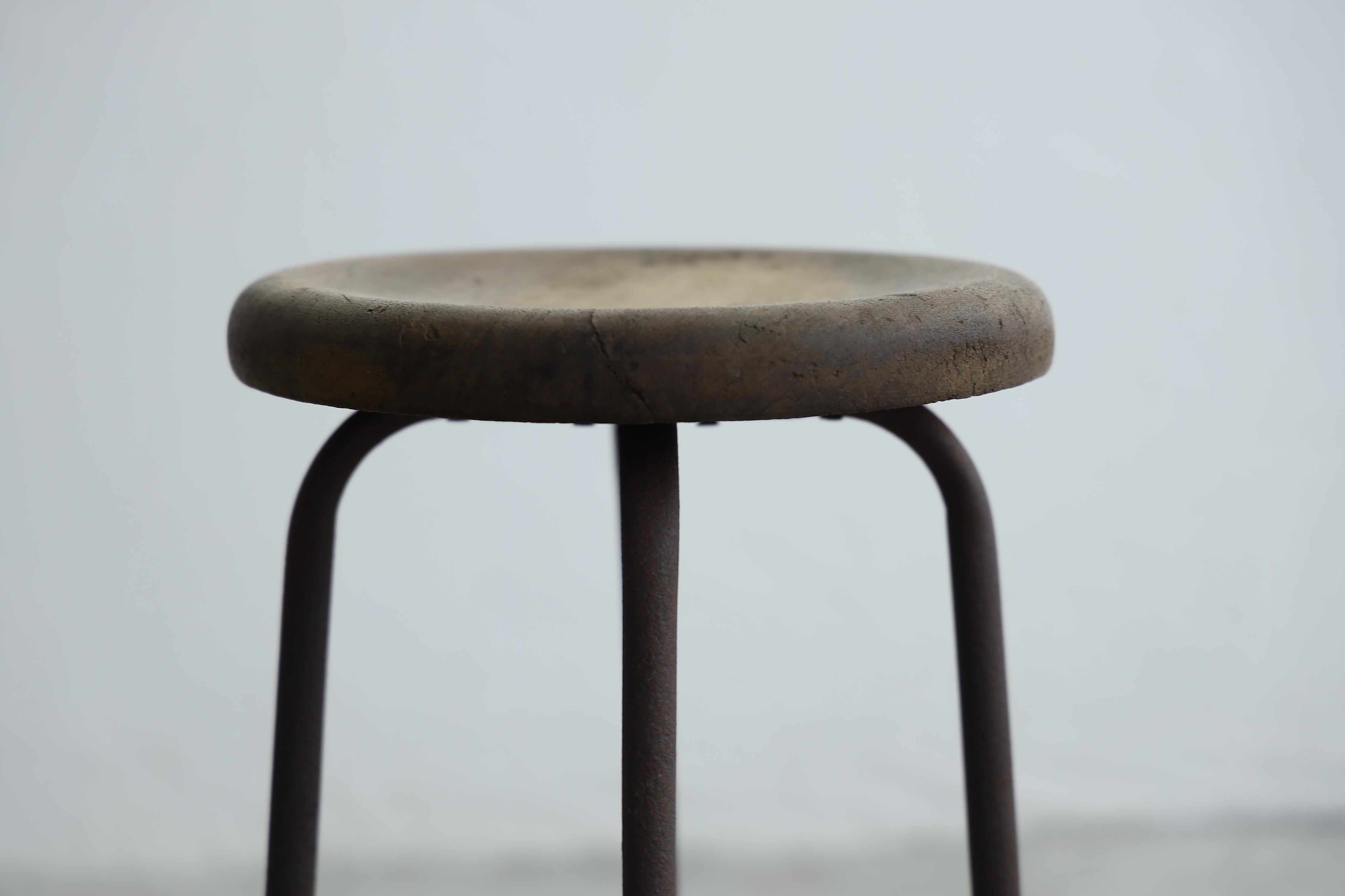 Un petit tabouret robuste en bois de cerisier et pieds en fer.
L'assise épaisse est légèrement concave vers le centre, ce qui permet de soutenir le corps en douceur.
De fines fissures et rayures subsistent à la surface, lui conférant une texture qui