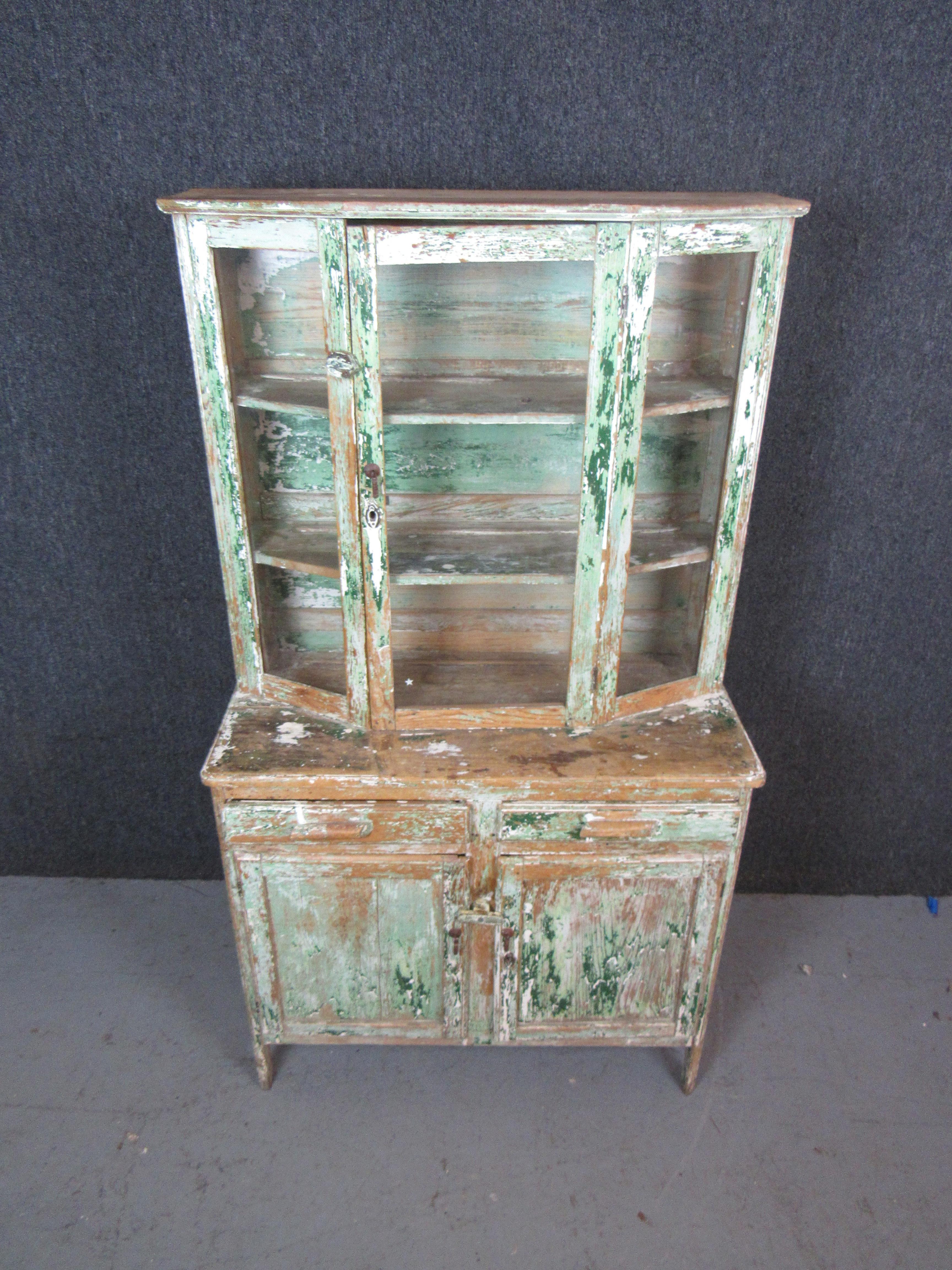 Bring home truly one-of-a-kind home decor with this stunningly distressed primitive Mexican solid pine hutch! Layers of green, blue, and white paint have steadily worn away over the years revealing the naturally knotty wood grain underneath. Heavily