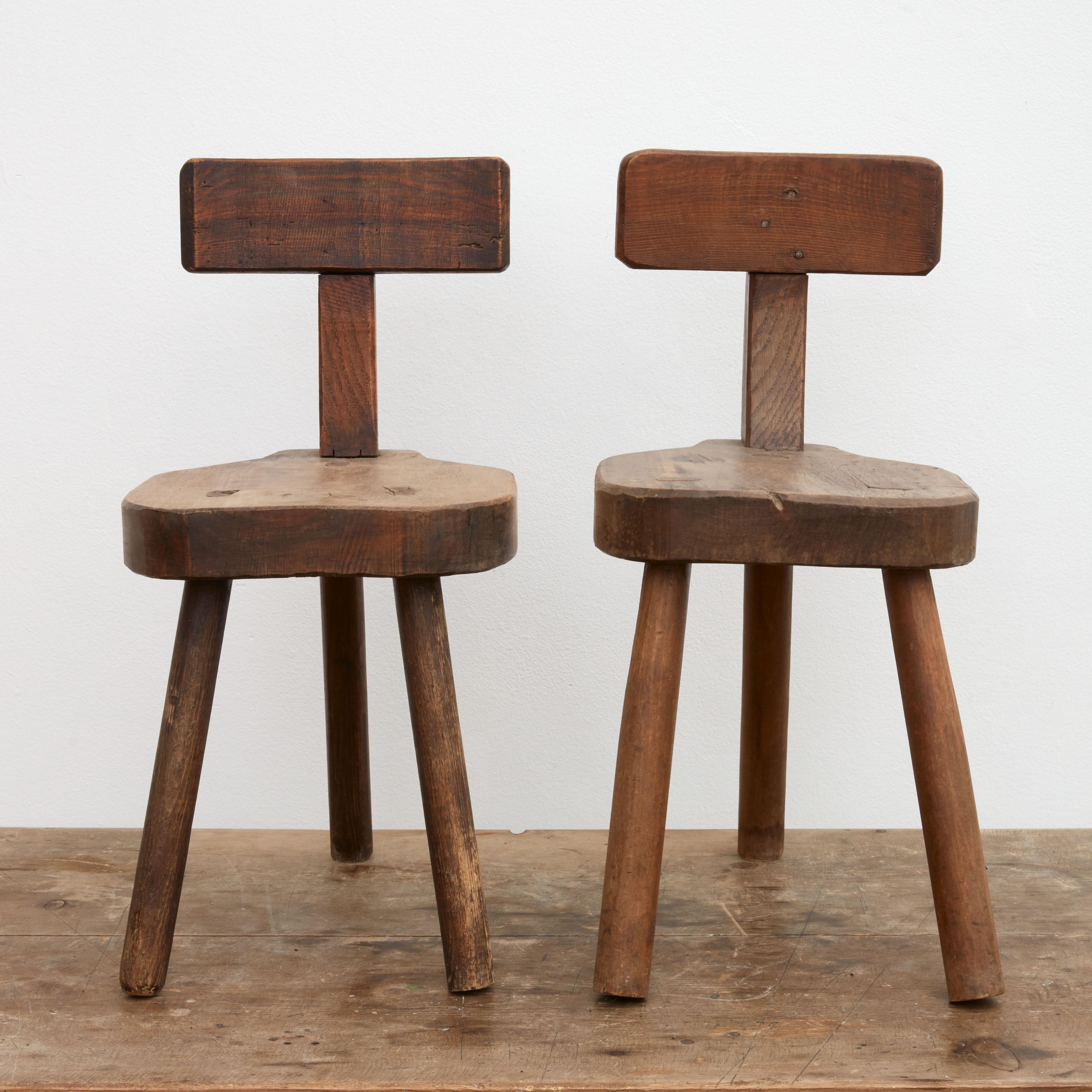 Pair of primitive three-legged miniature milking chairs.