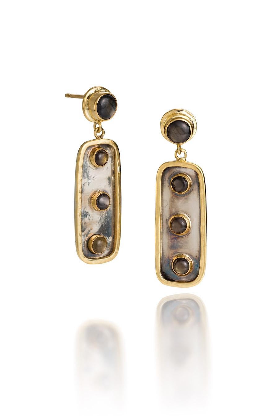 18KY, Oxidized Silver and Black Star Sapphire earrings are one-of-a-kind earrings.
Calder meets West African art was the inspiration for these Primitive/Modern earrings.  The Black Star Sapphires set in 18KY gold bezels catch the light and pop