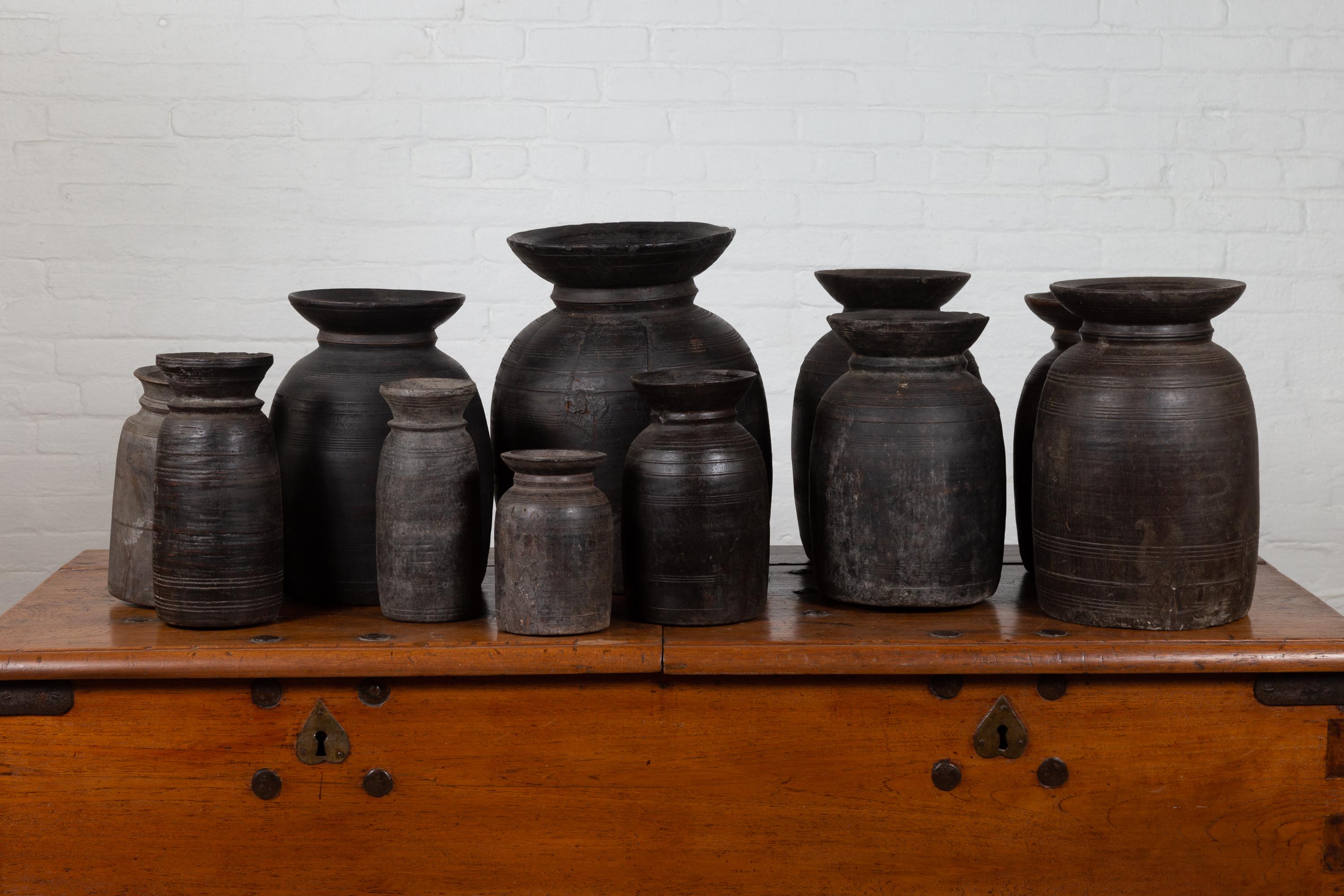 Antique Nepalese wooden ghee pots of various shapes and dimensions, sold in sets of three or five. Highly decorative, these wooden jugs will make for great accents in any room, particularly displayed in a kitchen, dining room or living room. Created